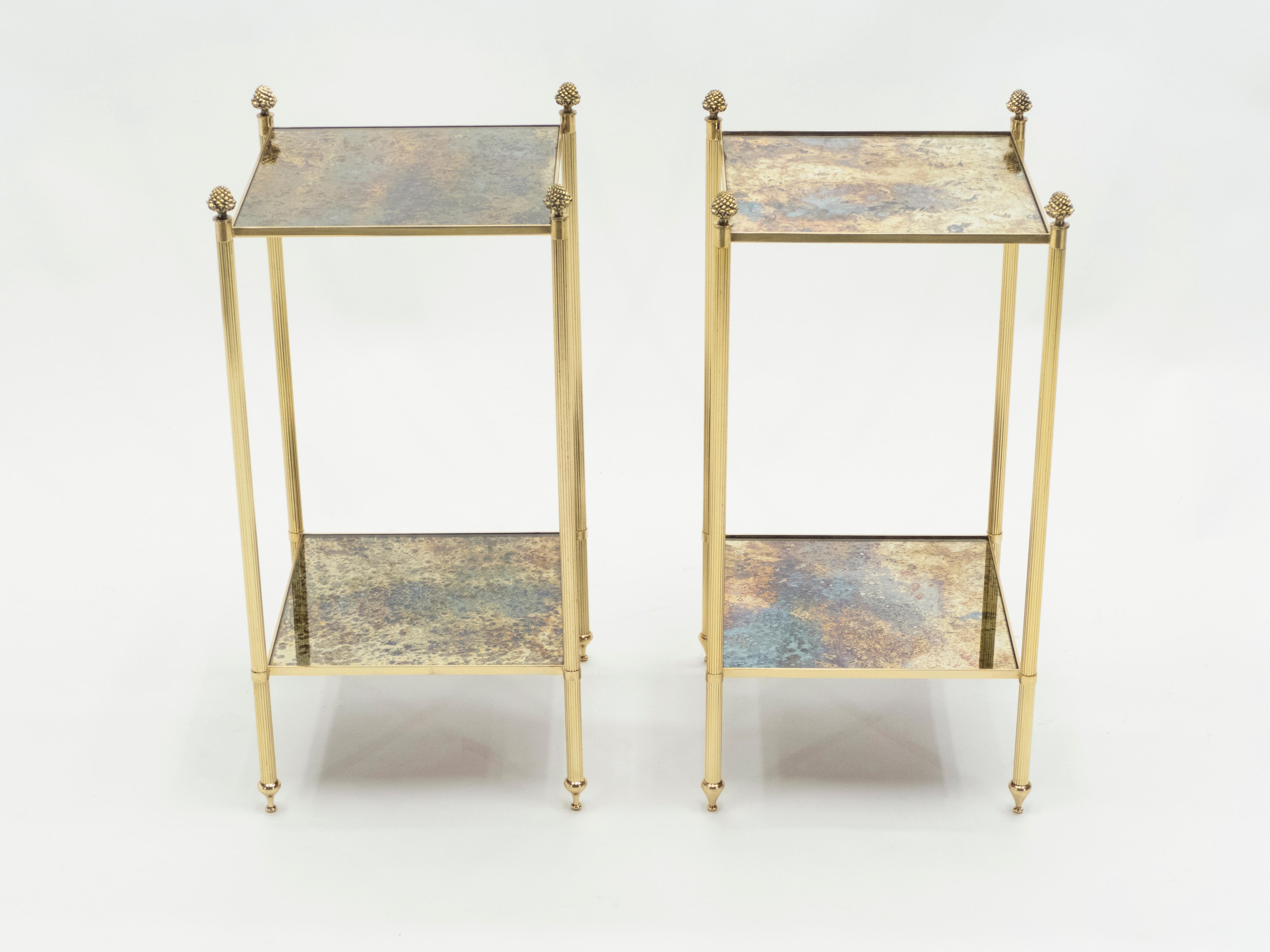 This pair of two-tier end tables by French design house Maison Jansen was created with solid brass, typical French neoclassical pine cone, and beautiful old patina mirror circa 1960. The two-tier mirrors are timeless and smooth, while the brass feet