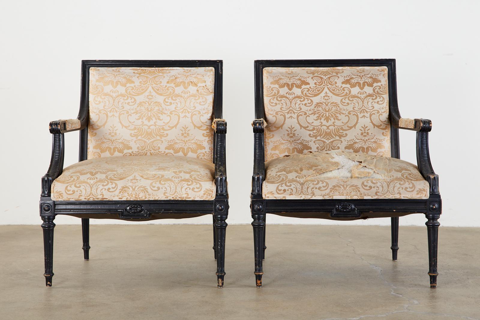 Dramatic pair of French Louis XVI style fauteuil armchairs attributed to Maison Jansen. The chairs are in 