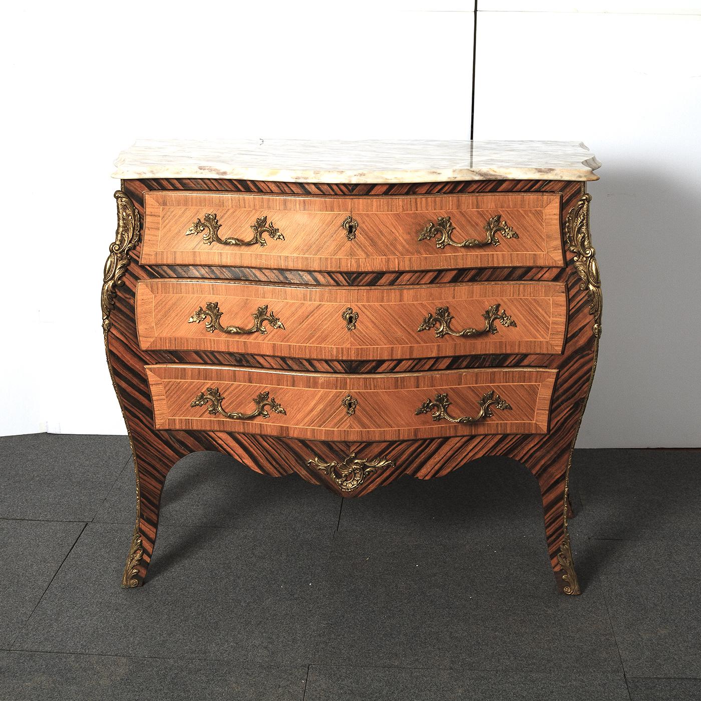 An unusual Pair of French Louis XV style marble top commodes. The serpentine molded edge marble tops above a serpentine and bombay form case with three shaped kingwood and satinwood line inlaid drawers framed by exotic Brazilian Rosewood. Having