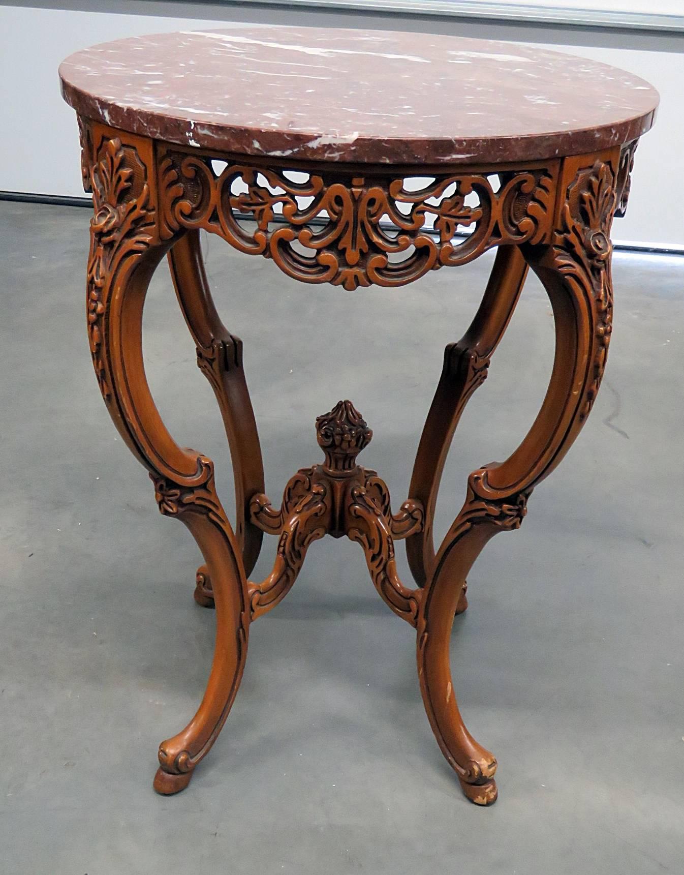 Pair of French heavily carved walnut end tables with marble tops.