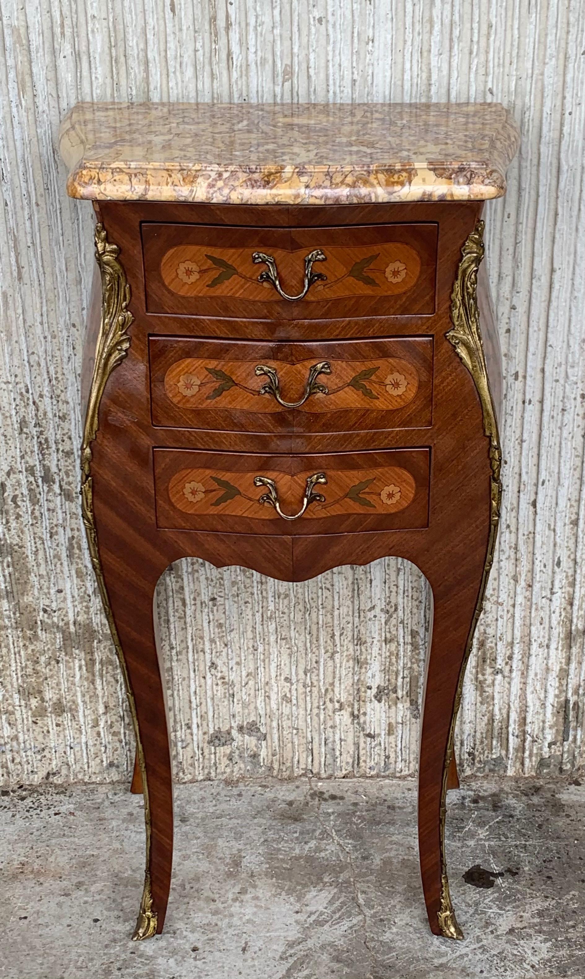 Mesillas de noche a juego de madera de rey de estilo Luis XV, cada una con tres cajones con marquetería floral sobre fondo de madera de rey a juego. Las piezas tienen una marquetería floral en ambas caras y conservan sus originales y bellas