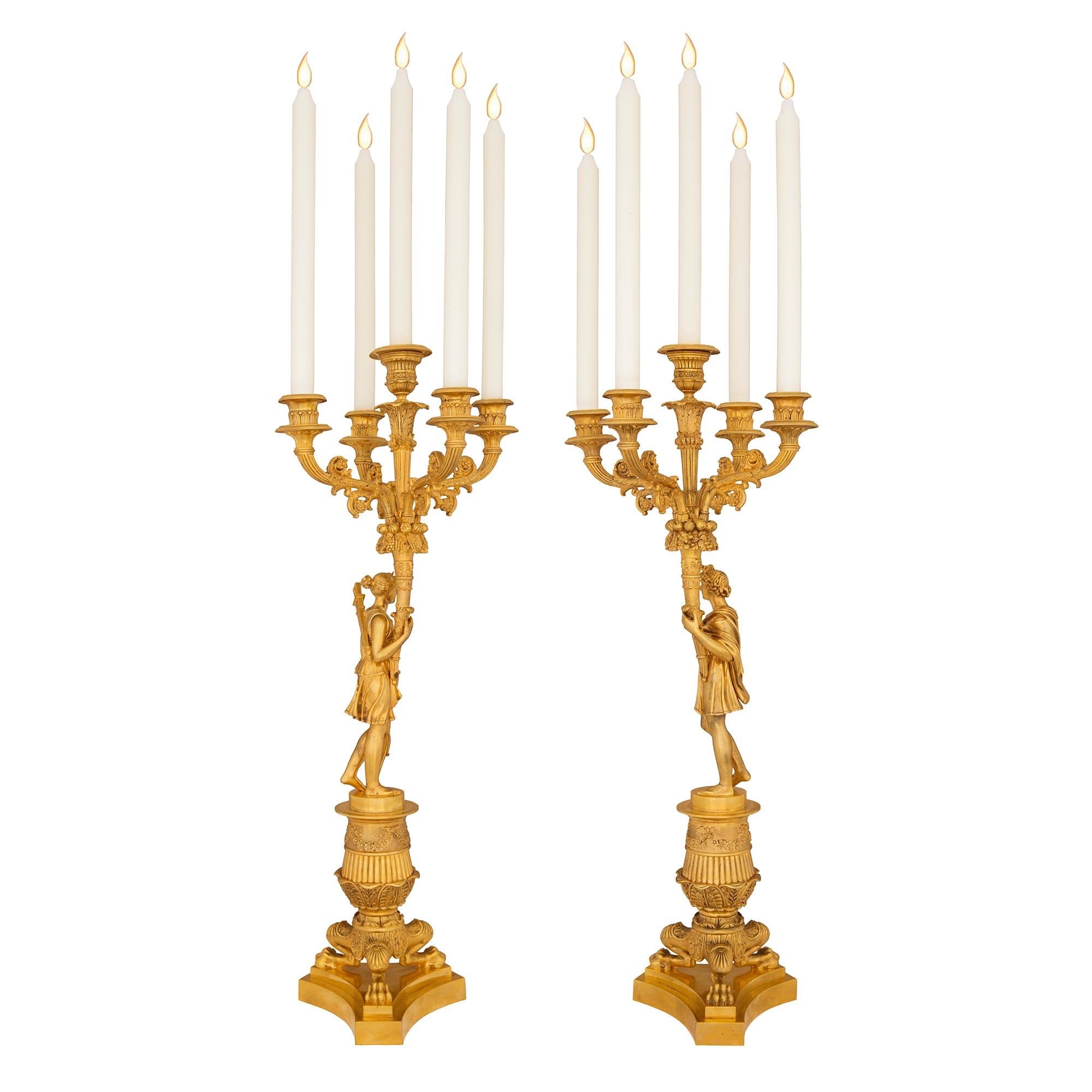An impressive and high quality pair of French mid 19th century Charles X period ormolu candelabras of Diana the huntress and Augustus. Each candelabra is raised by a triangular base with concave sides and three striking paw feet with beautiful