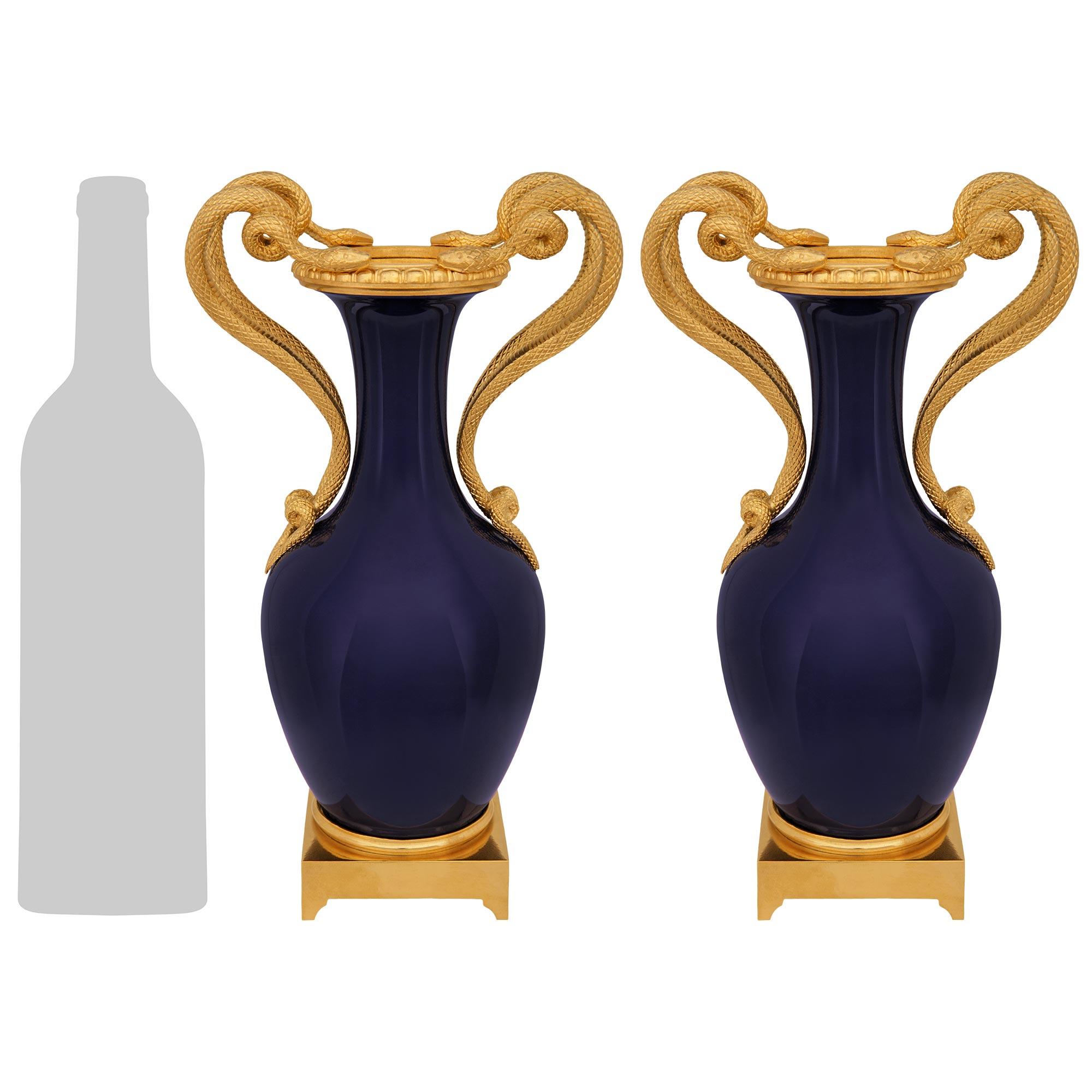 A handsome and high quality pair of French mid 19th century Louis XVI st. Sèvres Porcelain and Ormolu vases. Each wonderful cobalt blue vase is raised on a square Ormolu base with four small supports and a mottled top band. The baluster shaped