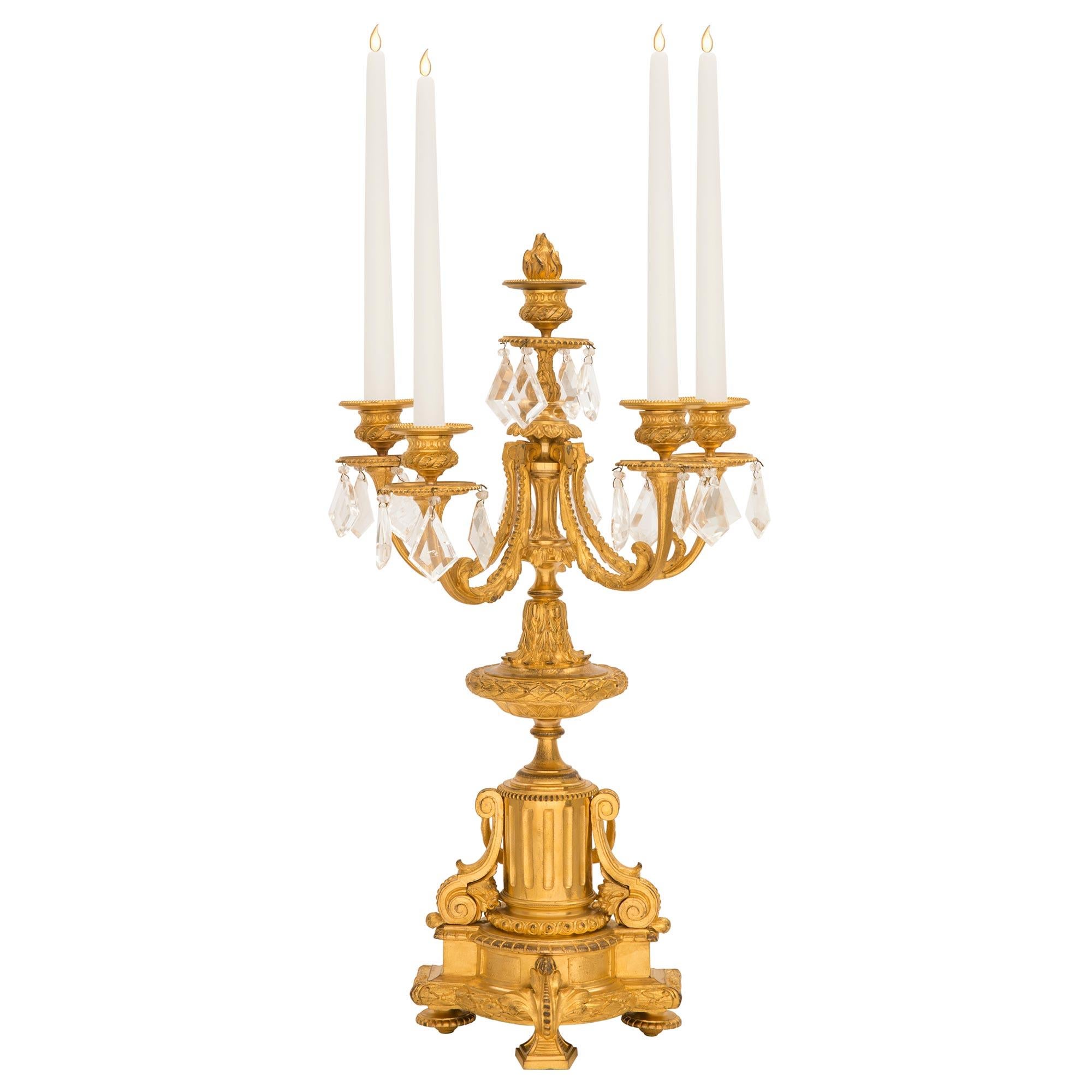An exquisite pair of French mid 19th century Louis XVI st. ormolu and rock crystal candelabras. Each beautiful six arm candelabra is raised by a fine elegantly curved foliate support at the front with elegant topie shaped feet at each side. A finely