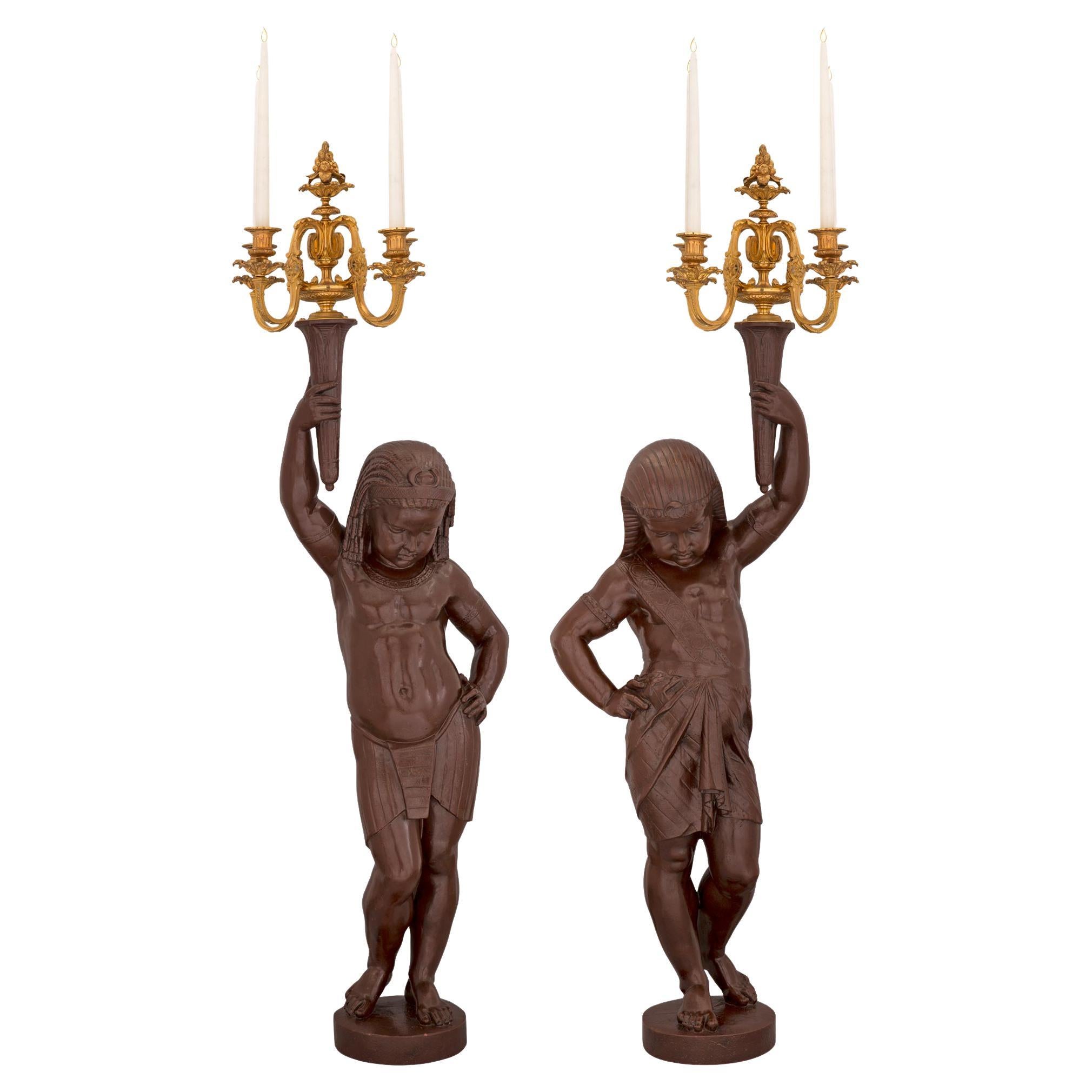 Paire de statues de candélabres en bronze patiné et bronze doré du milieu du XIXe siècle en vente
