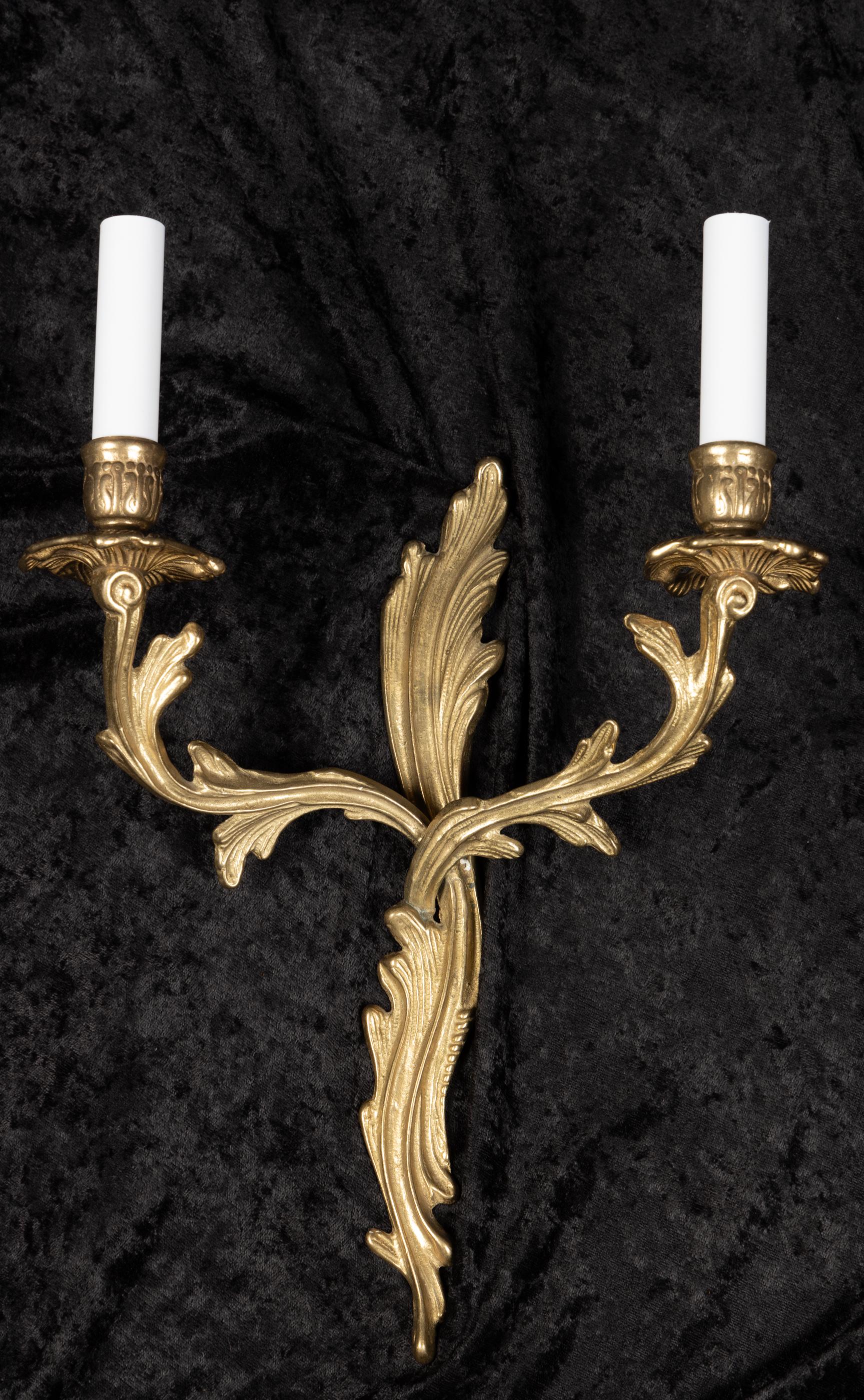 Beautiful pair of French two light sconces crafted in the Rococo style. The bronze pair dates back to the mid-20th century.

The price is for the pair which is sold and shipped together.

Each piece in our shop is professionally rewired and in