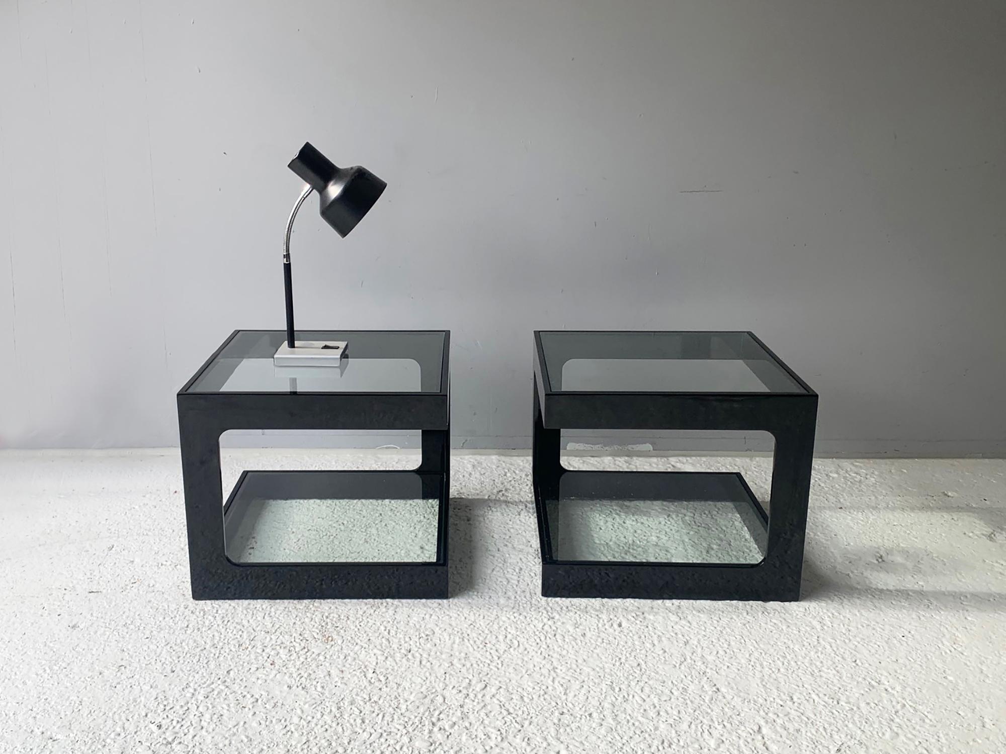 Angular cube shaped tables, work equally aswell as coffee tables or bedside tables. Produced in France in the late 1970s/early 1980s. Each has a high gloss black plastic frame with two clear glass surfaces.

Happy to sell individually or as a