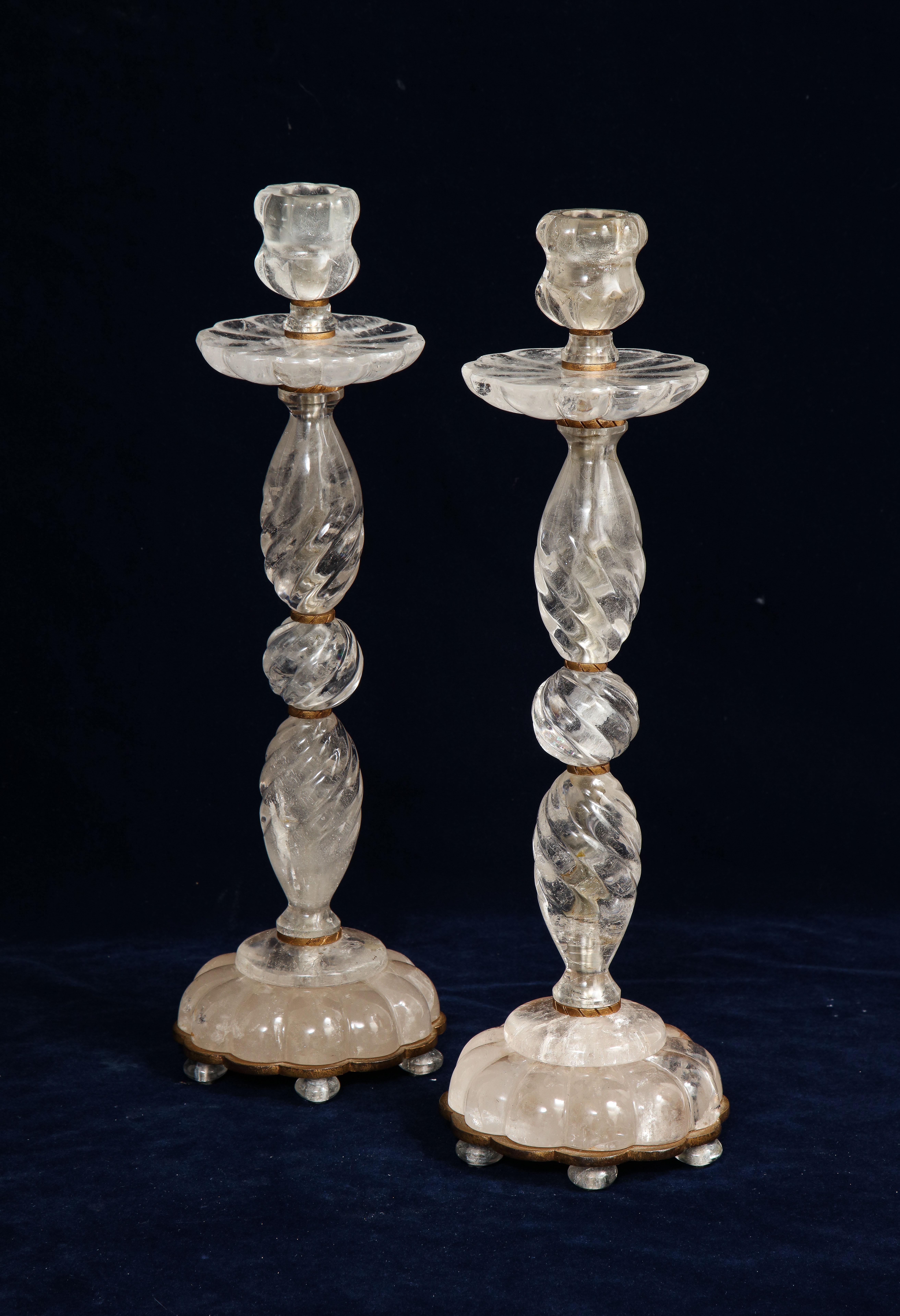 Une impressionnante paire de chandeliers en cristal de roche de style Louis XVI français du milieu du siècle, sculptés et polis à la main sur des montures en bronze patiné. Chaque chandelier est magnifique avec de multiples sections de cristal de