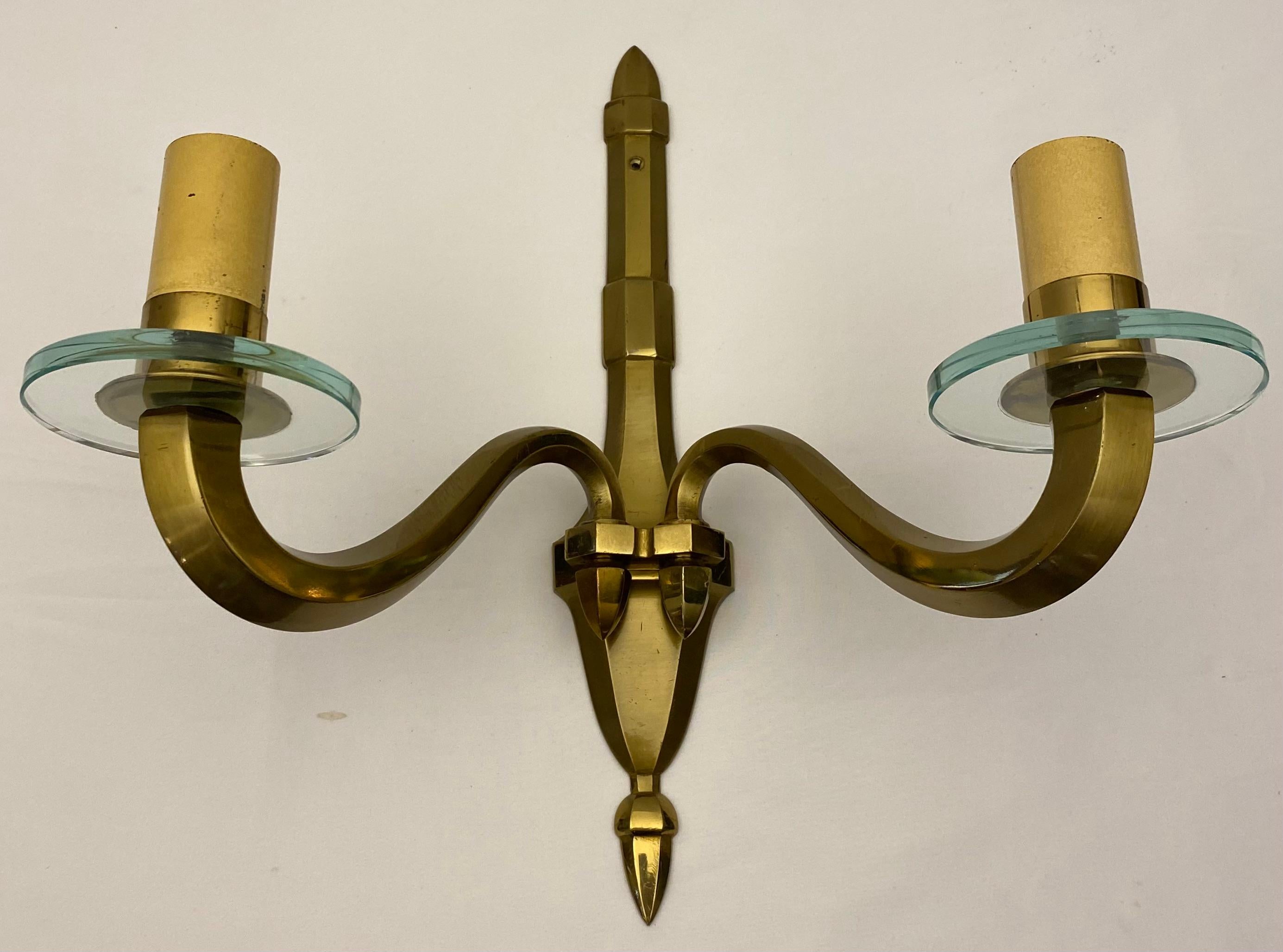 Coppia di applique francesi di metà secolo (anni '40) in bronzo di ottima qualità con due bracci a voluta e cornucopia con bobeche in vetro rotondo e sostenuti da una piastra posteriore sagomata.  Queste bellissime applique sono attribuite a Jean