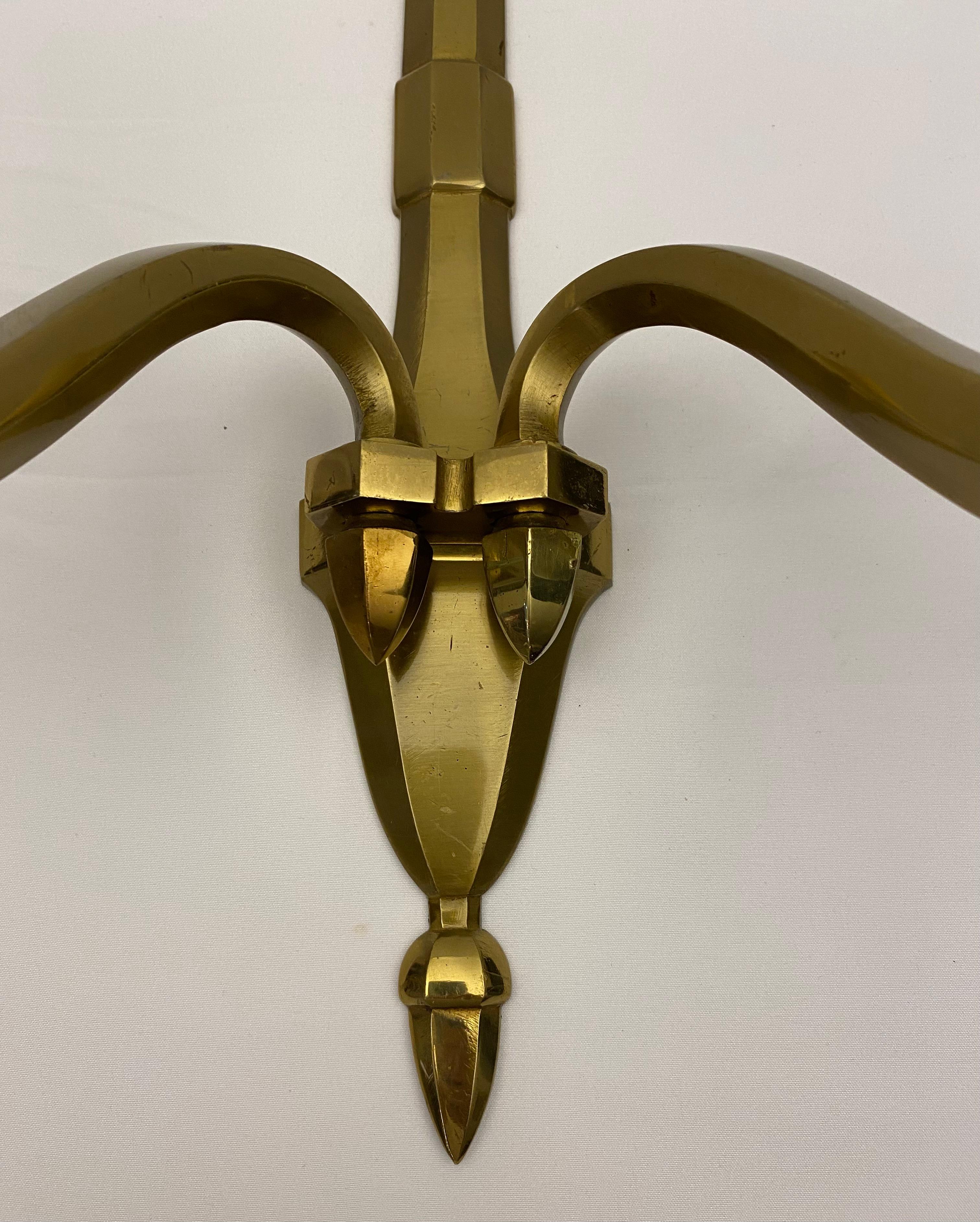 A very good quality Pair of French Mid-Century (1940's) bronze wall sconces with two scroll and cornucopia design arms with a round glass bobeche and supported by a gorgeous shaped backplate. These beautiful wall sconces are in the style of Jean