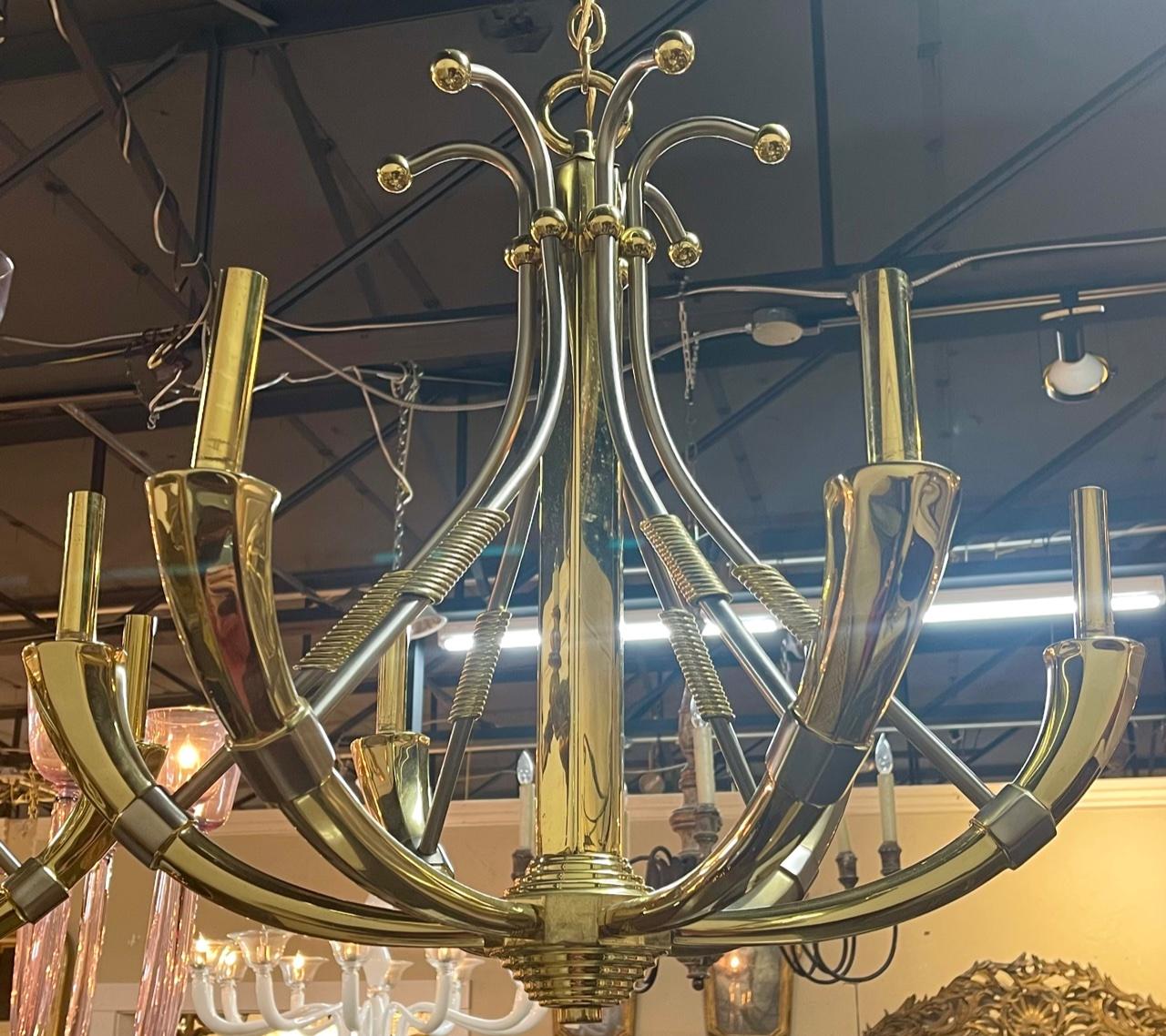 Pair of French mid-century Jansen steel and brass chandeliers. Circa 1960. Perfect for today's transitional designs! These chandeliers have been professionally re-wired, cleaned and is ready to hang. Includes matching chain and canopy.
   