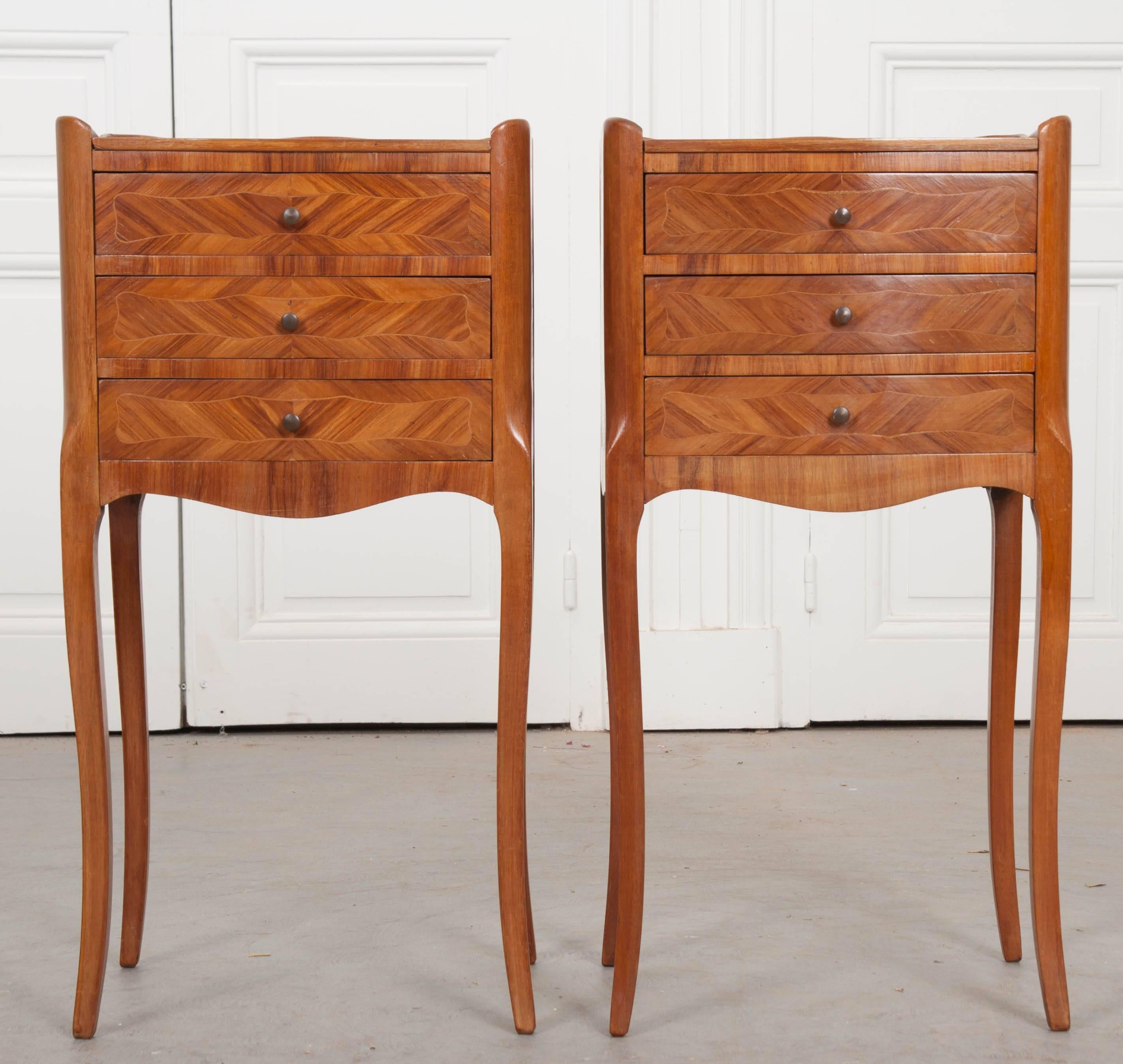 A refined pair of satinwood marquetry bedside tables from 1950s, France. The tables each have three drawers, with their façades finished in exceptional satinwood marquetry and inlay. The tops and sides have also been finished in this mesmerizing
