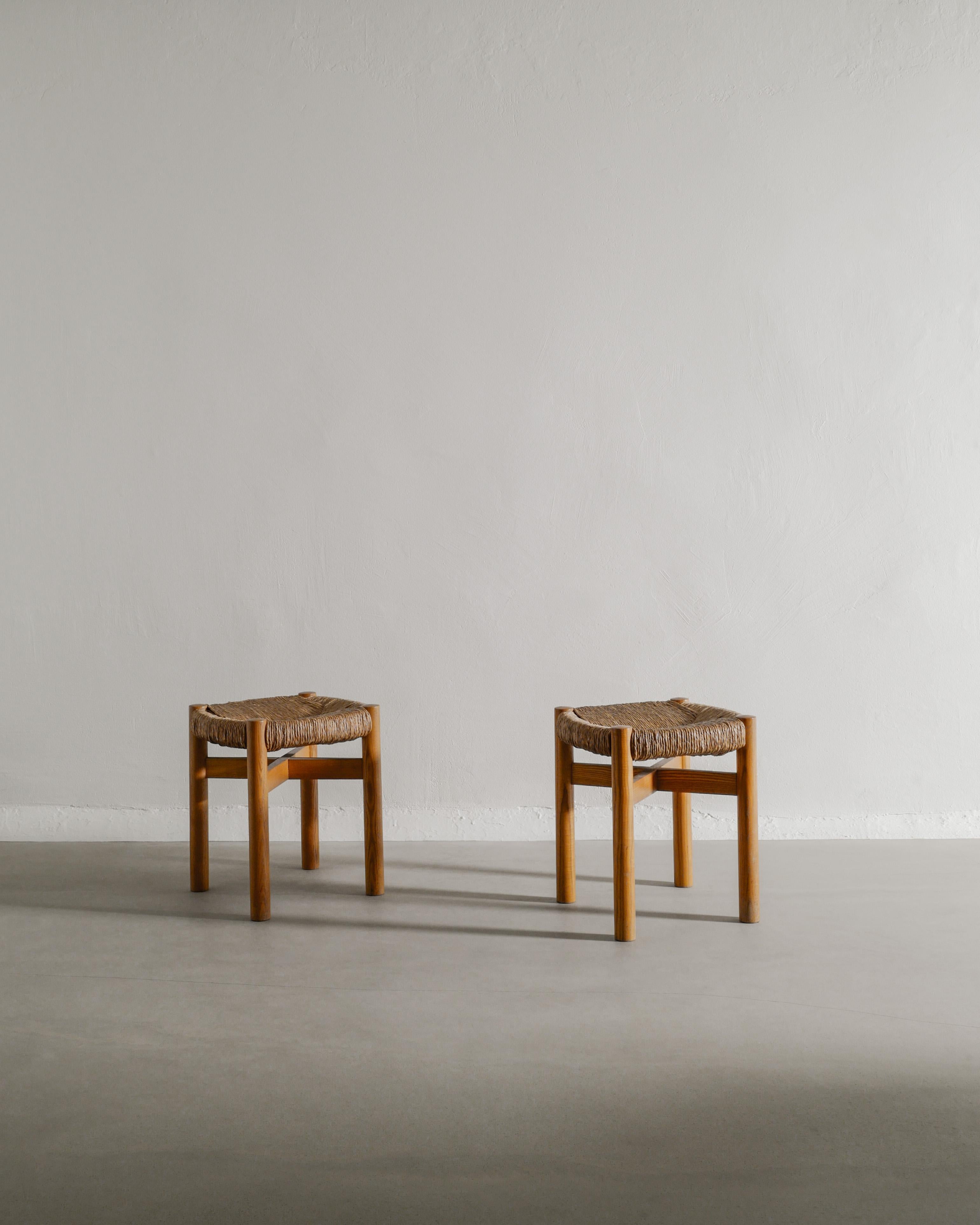 Rare pair of French mid century wooden stools in ash and straw seats by Charlotte Perriand for Steph Simon Paris, 1960s. In good original condition with matching condition and patina. Acquired from the original owner. 

Dimensions: 41 cm / 16.15
