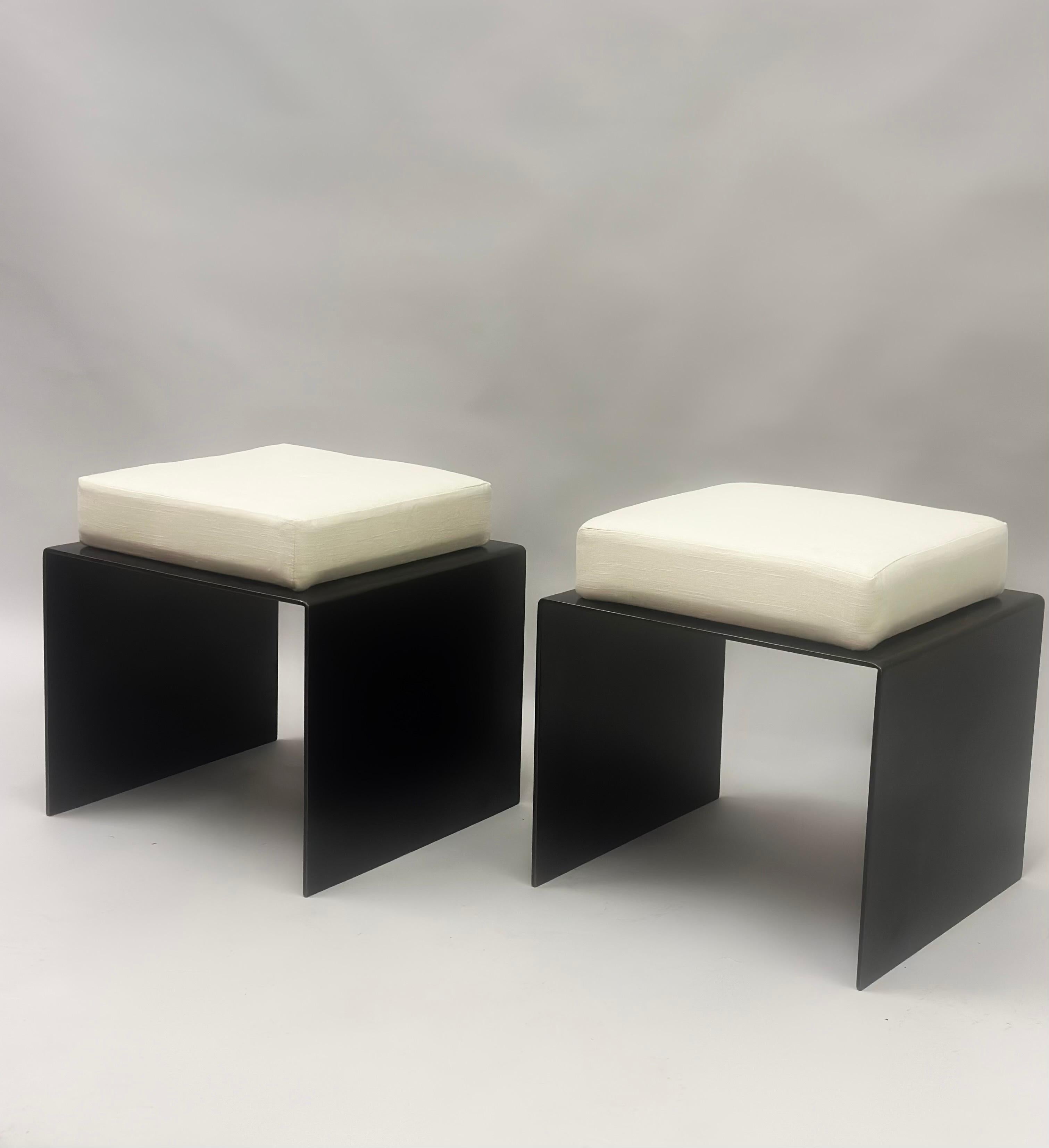 Elegant pair of French midcentury style Modernist stools / benches / ottomans with pure forms and elegant lines, constructed in wrought iron and with upholstered cotton seats. The pieces achieve a perfect balance of form and function. They please