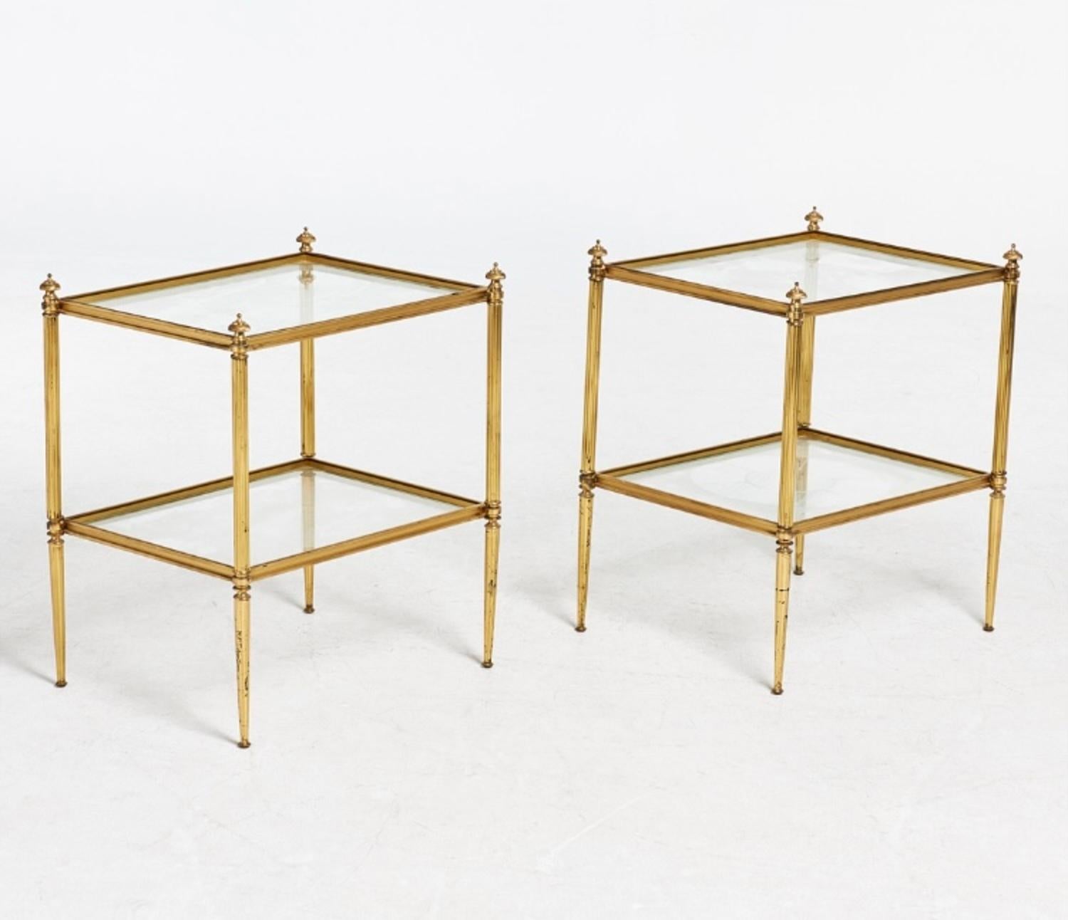 A pair of French Maison Jansen-style tables based on the Louis Xvi model, in gilded brass and two trays with glass tops are very decorative tables with various uses, in Good condition.