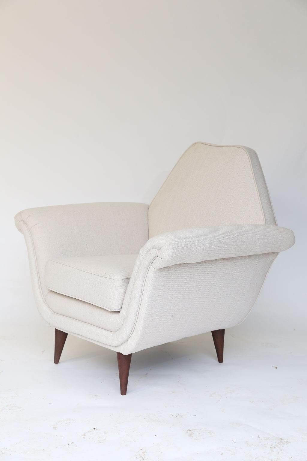 Petite in size and full of midcentury style, this pair of French Mid-Century Modern chairs is sure to delight. Newly restored and upholstered in a linen blend fabric and standing on wood angular legs, these chairs will withstand the test of time.