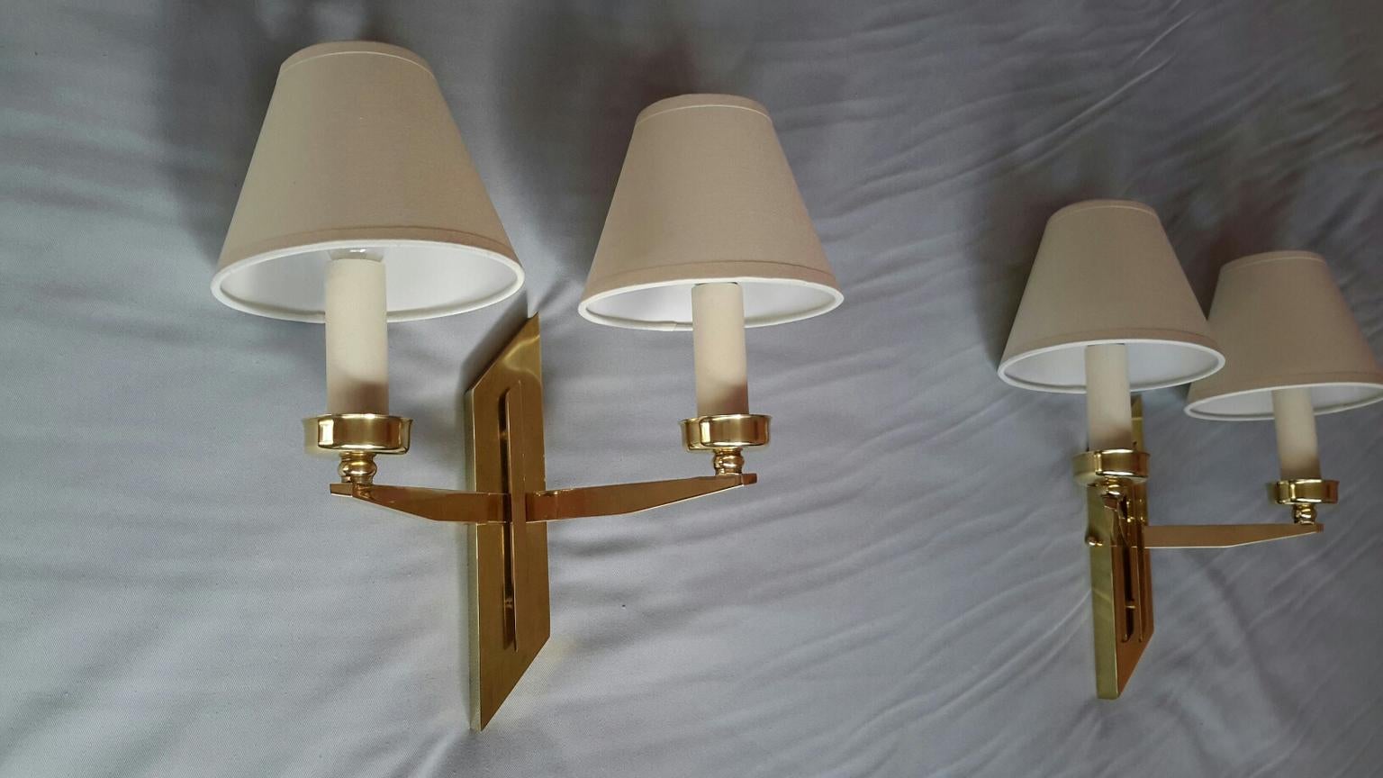 Very elegant pair of French Mid-Century Modern double arm sconces, 1950s in gilded bronze with white cotton shades by Maison LUNEL.
The sconces are in perfect condition, the new wiring fits the US standards. The White cotton shades are