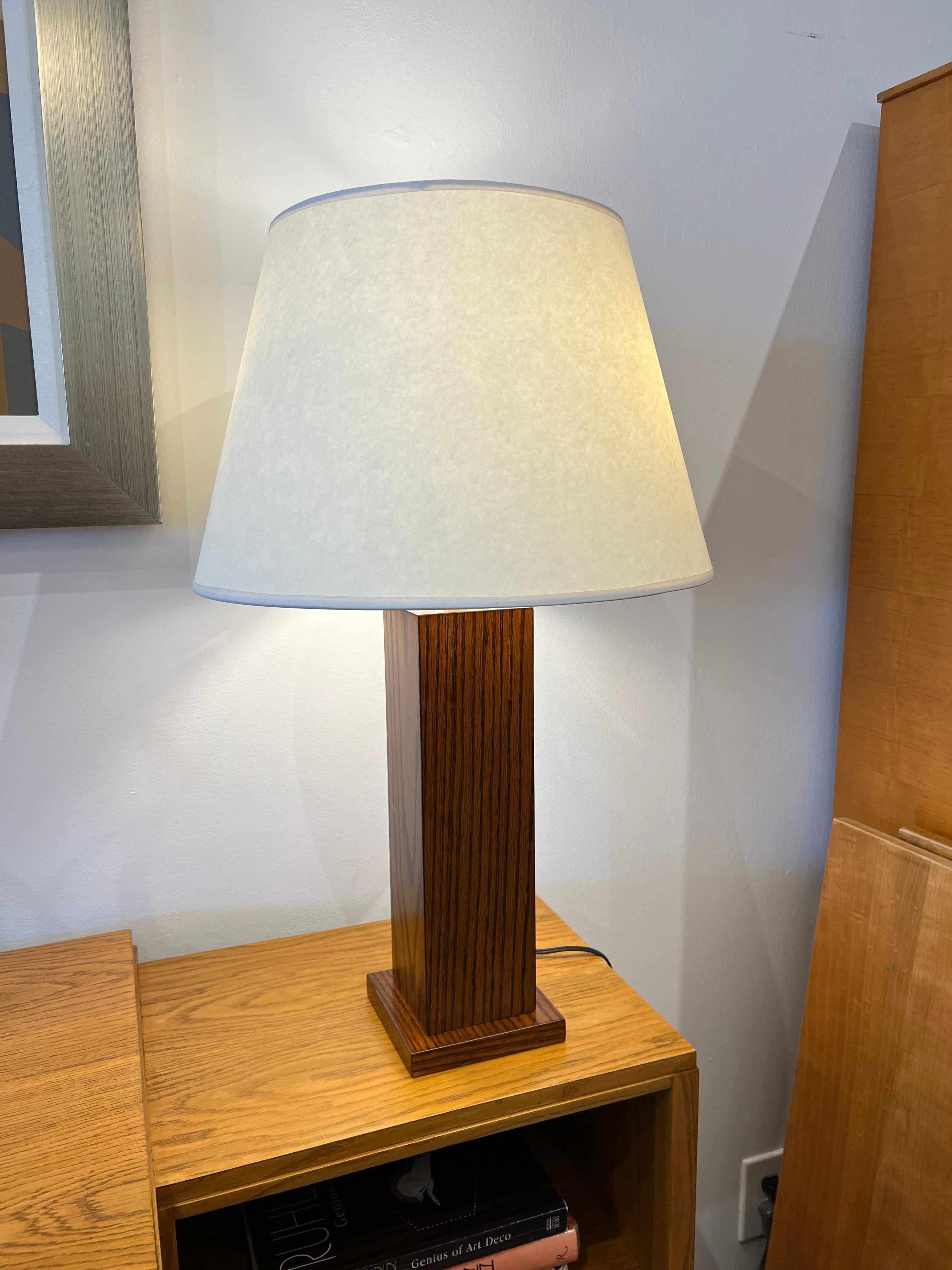 Pair of Oak lamps and Parchment White Shades in the style of Jean Michel Frank are a timeless classic of the mid-century design. Inspired by the French Art Deco movement, these lamps feature a delicate silhouettes and smooth lines that create a