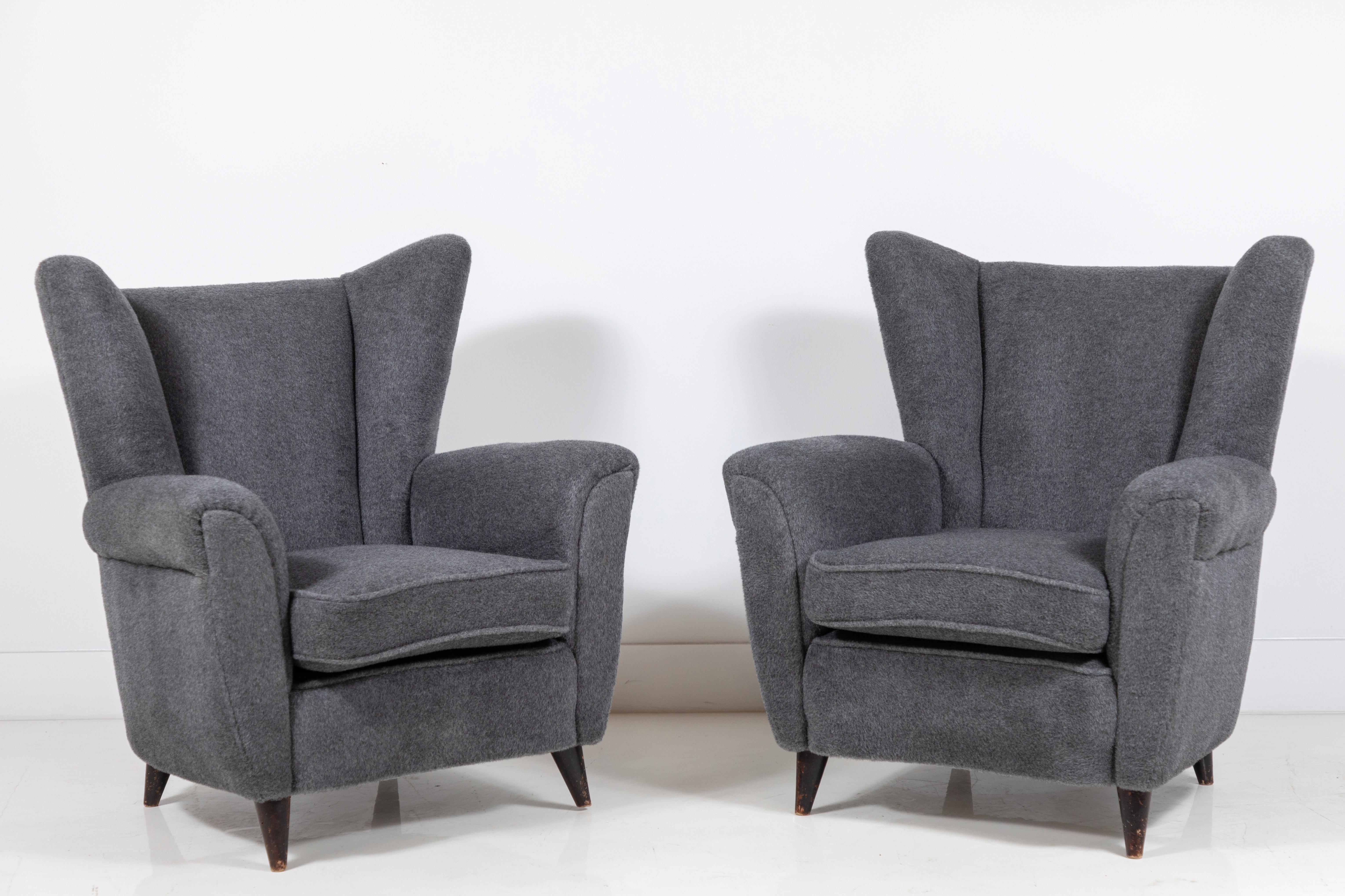 Pair of French midcentury wingback chairs upholstered in a grey mohair. Original fabric and original finish on the legs.