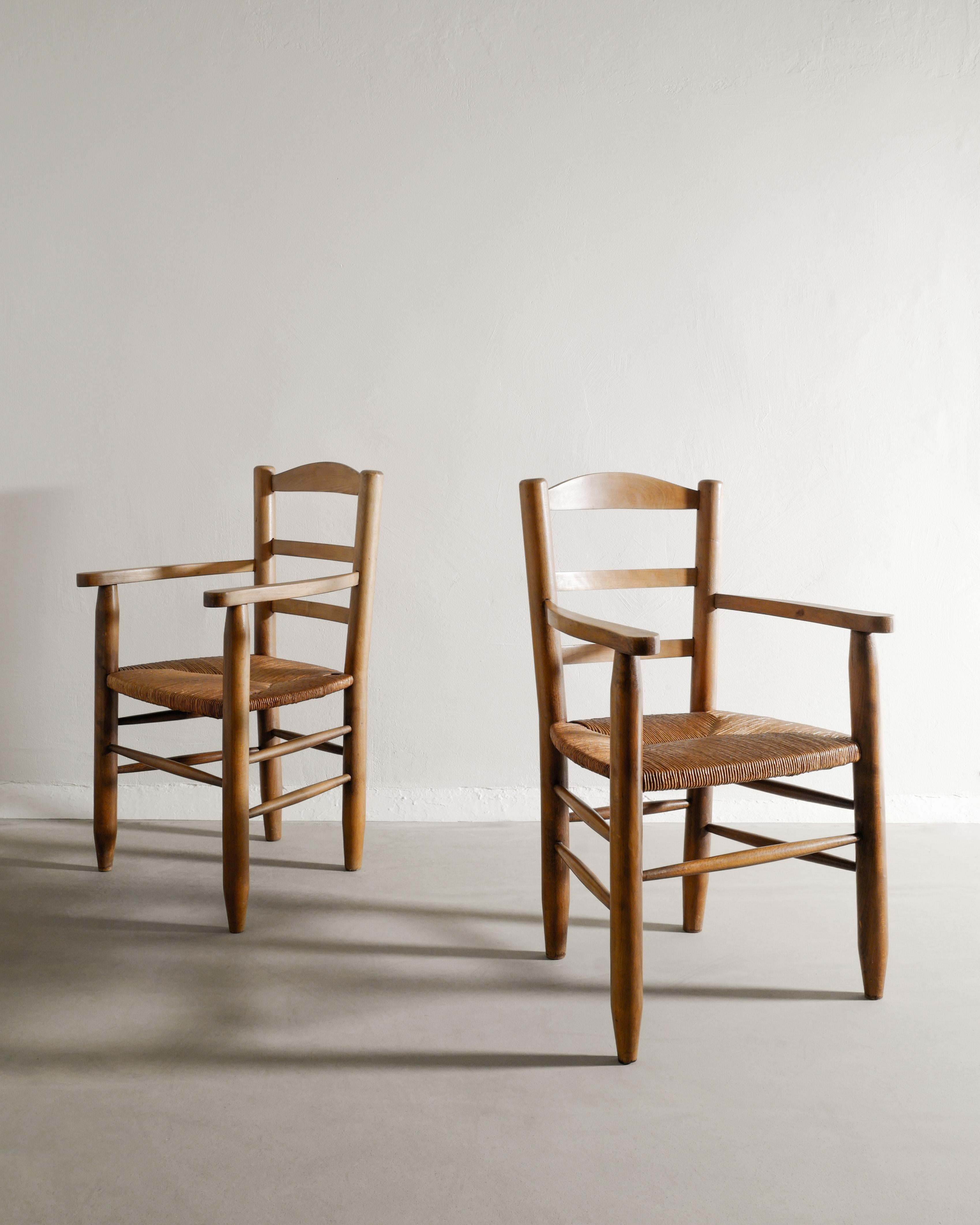 Rare paire de fauteuils en bois du milieu du siècle dans le style de Charlotte Perriand. Fabriqué en France, les années 1950 en bois d'orme et les sièges en paille assortis. En bon état d'origine. 

Dimensions : H : 90 cm / 35.45