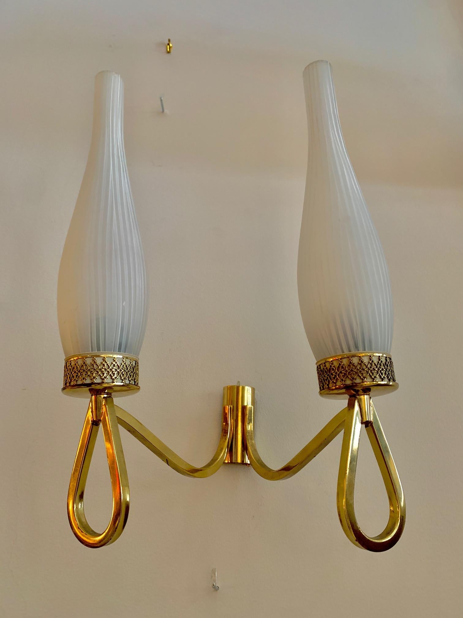 Pair of wall sconces around 1950, in the Maison Lunel style, with double arms, the entire structure is made of brass, the lampshades are original opaline glass. one of them have a small, almost priceless fault.