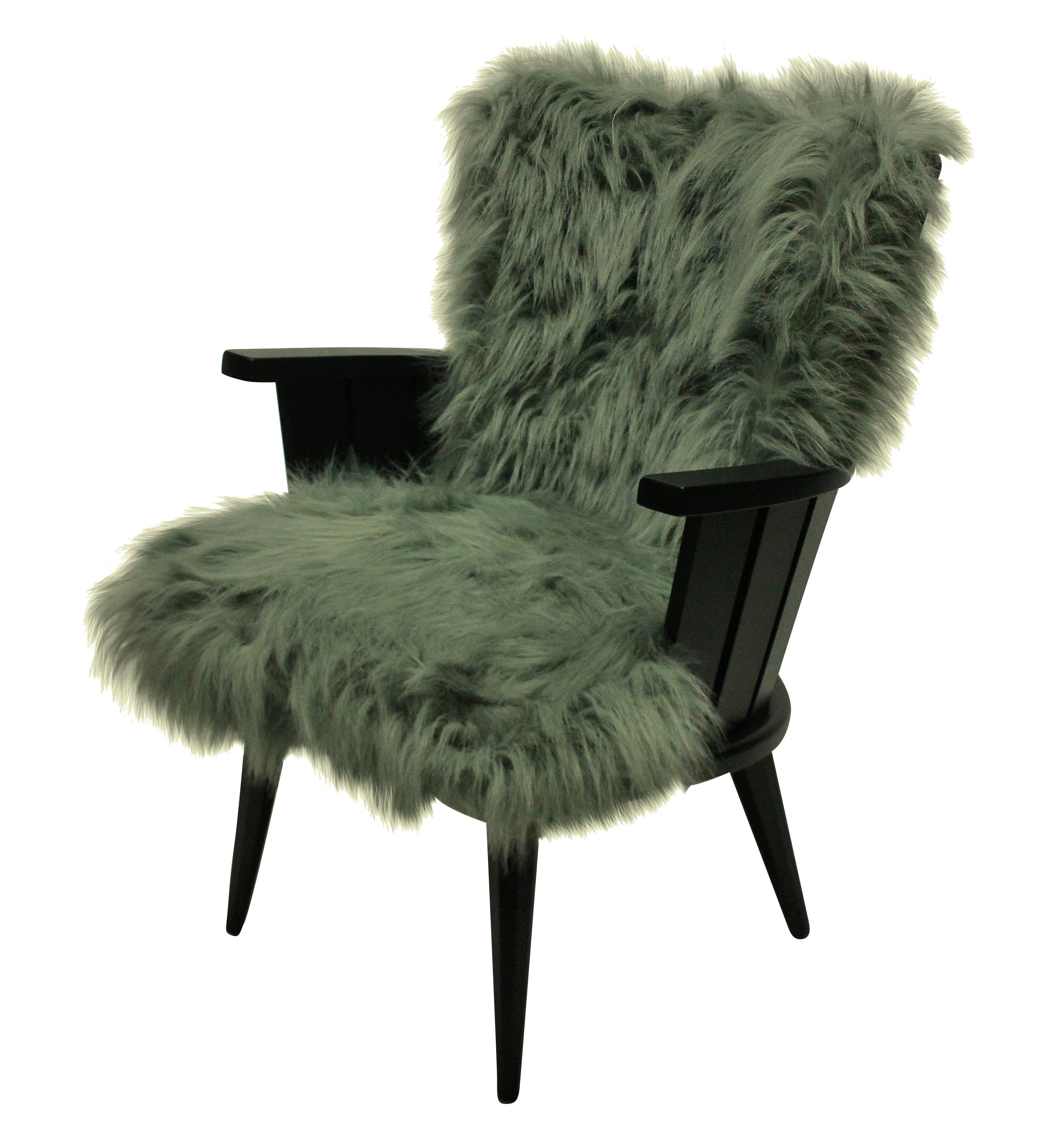 A pair of French midcentury armchairs of unusual design. In black lacquer with faux fur cushions.