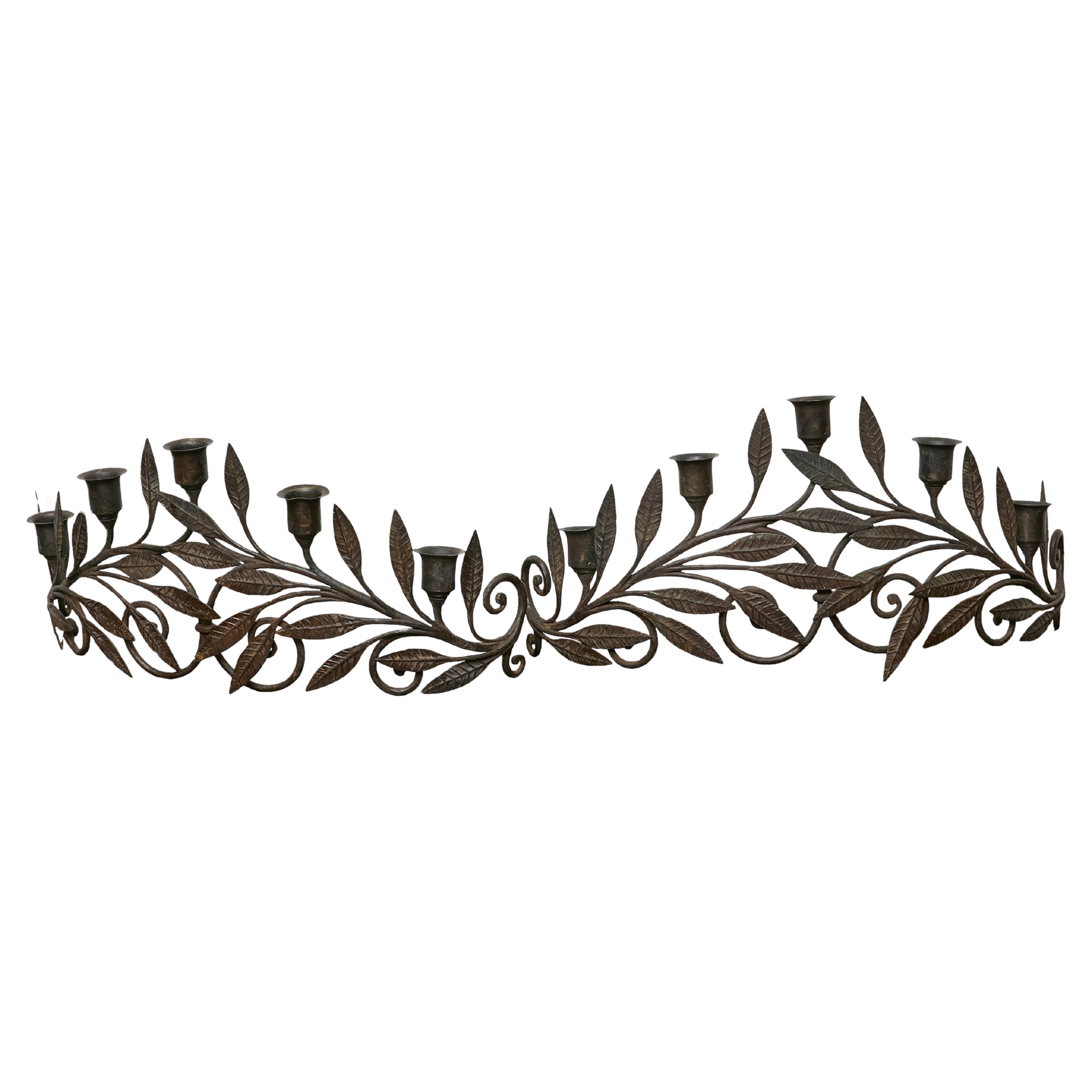 Crafted in France during the mid-20th century, this decorative pair of iron candleholders brings a sculptural, nature-inspired elegance to any interior. Designed in mirror image, each piece features five candle cups integrated into a flowing