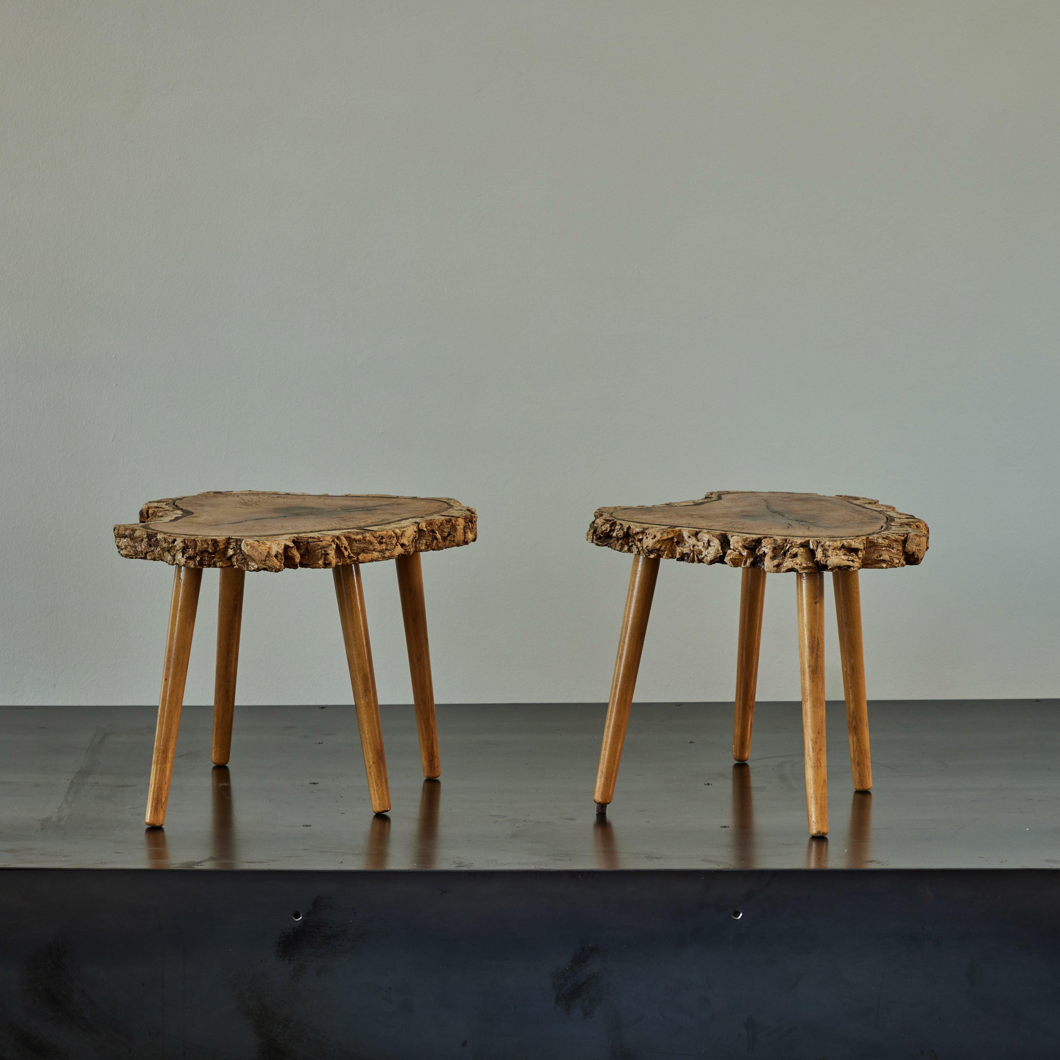 Pair of naturalistic French midcentury live edge wood tables. With blonde, slightly tapered legs, these tables celebrate the natural beauty of wood. Tactile, sculptural, and with a remarkable grain, the pair would bring an organic sexiness to any