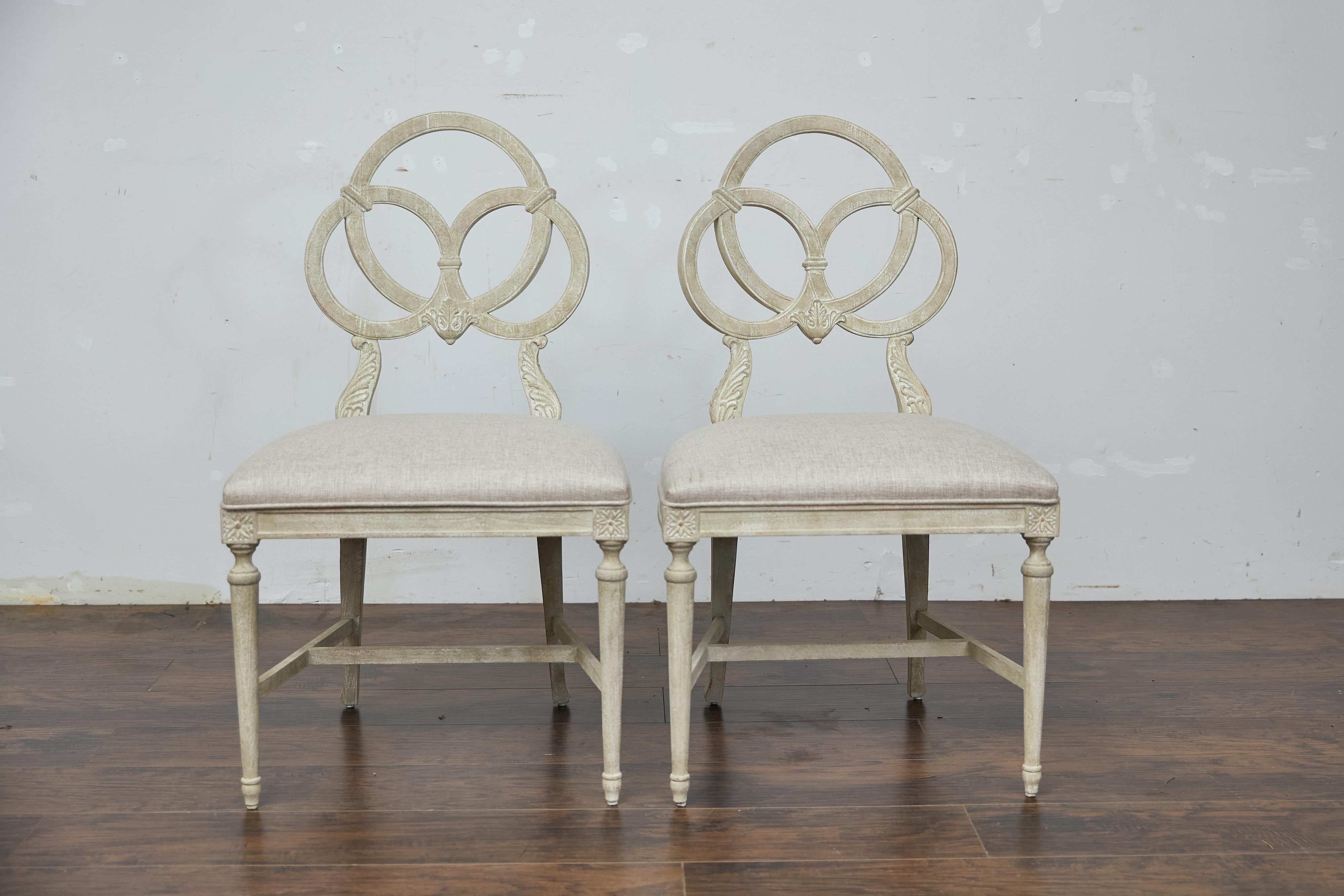 Paire de chaises d'appoint françaises sculptées du milieu du XXe siècle, conçues dans le style Louis XVI et nouvellement tapissées pour un usage moderne. Chaque chaise mesure 22 pouces de large par 18 pouces de profondeur et 38,75 pouces de haut,