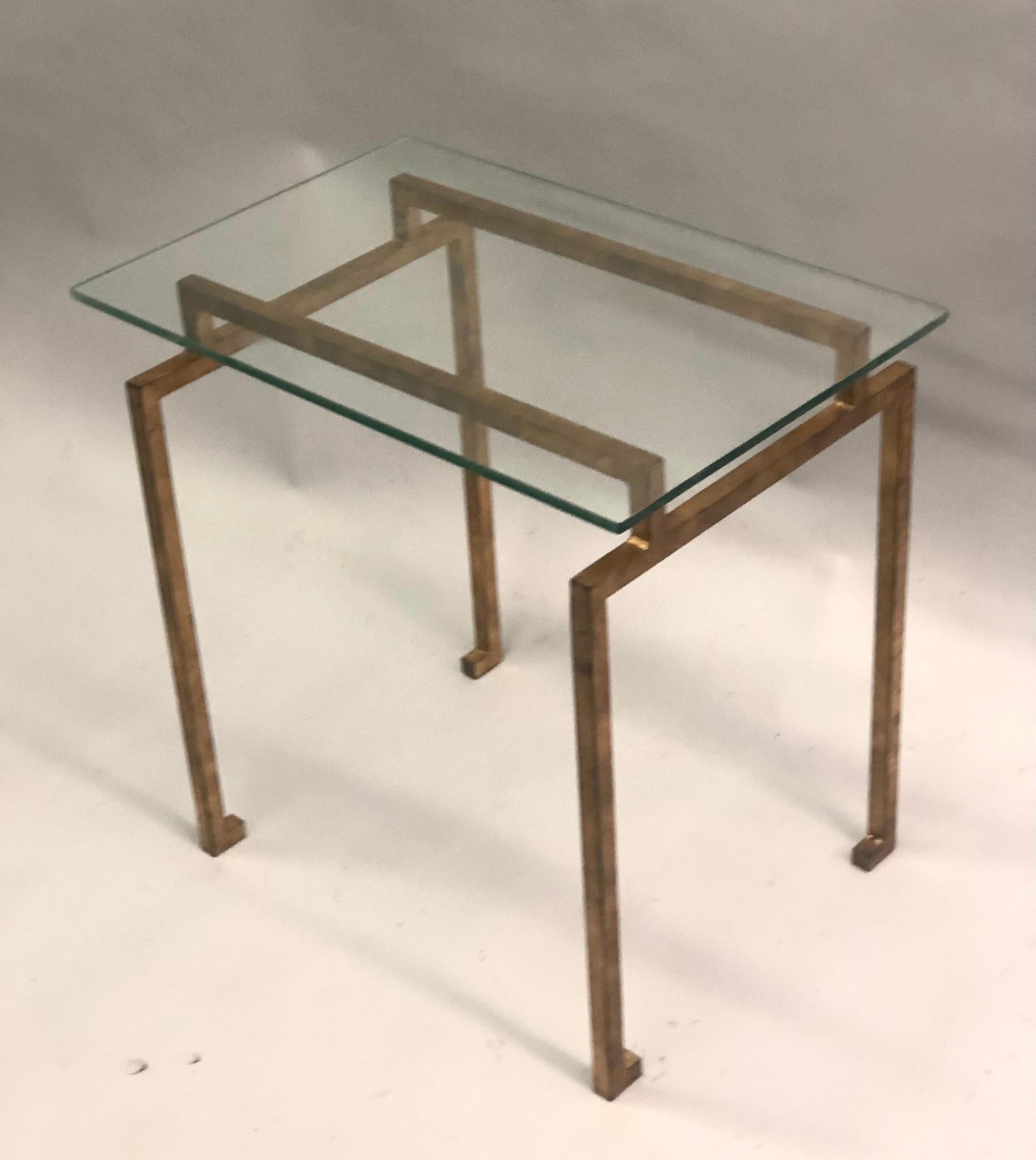 A pair of French midcentury style side or end tables in the modern neoclassical spirit. The tables are in gilt handwrought iron with delicate turned in sabots in the Egyptian taste.

Literature: Similar pair sold at Sotheby's New York, Important