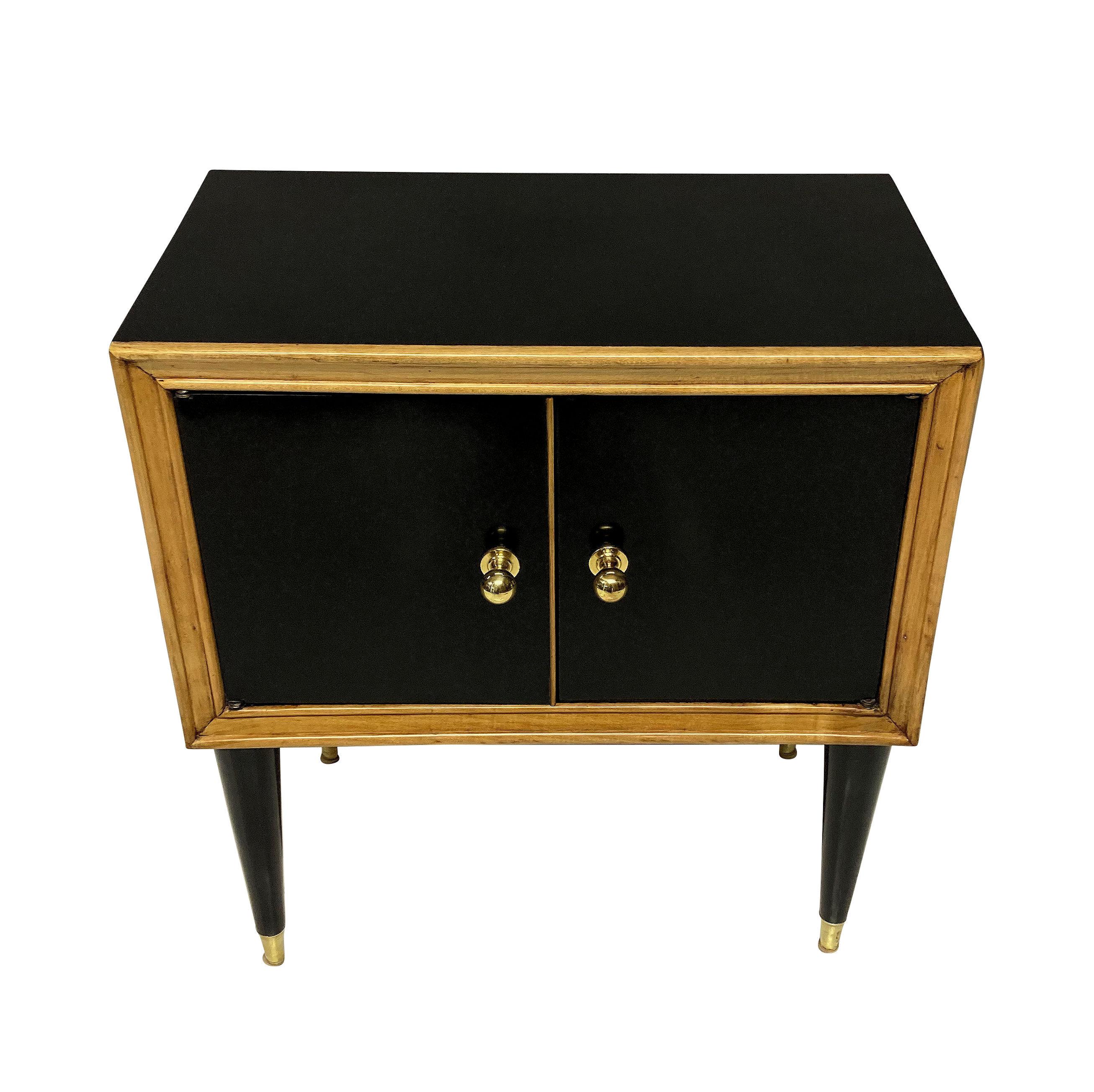 A pair of French midcentury nightstands, ebonised with brass sabot and handles and pale wood moulding detail.
