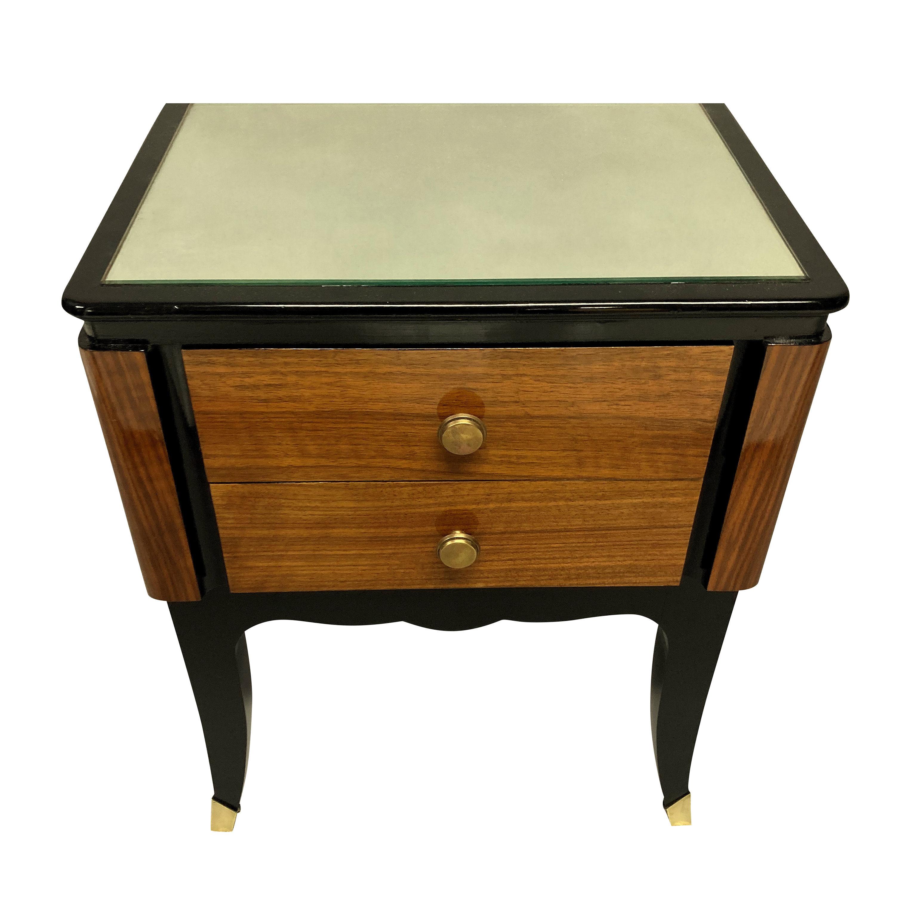 A pair of French midcentury night stands of good quality in rosewood with ebonised detail. With two drawers each, brass sabot feet and antiqued mirror glass tops.