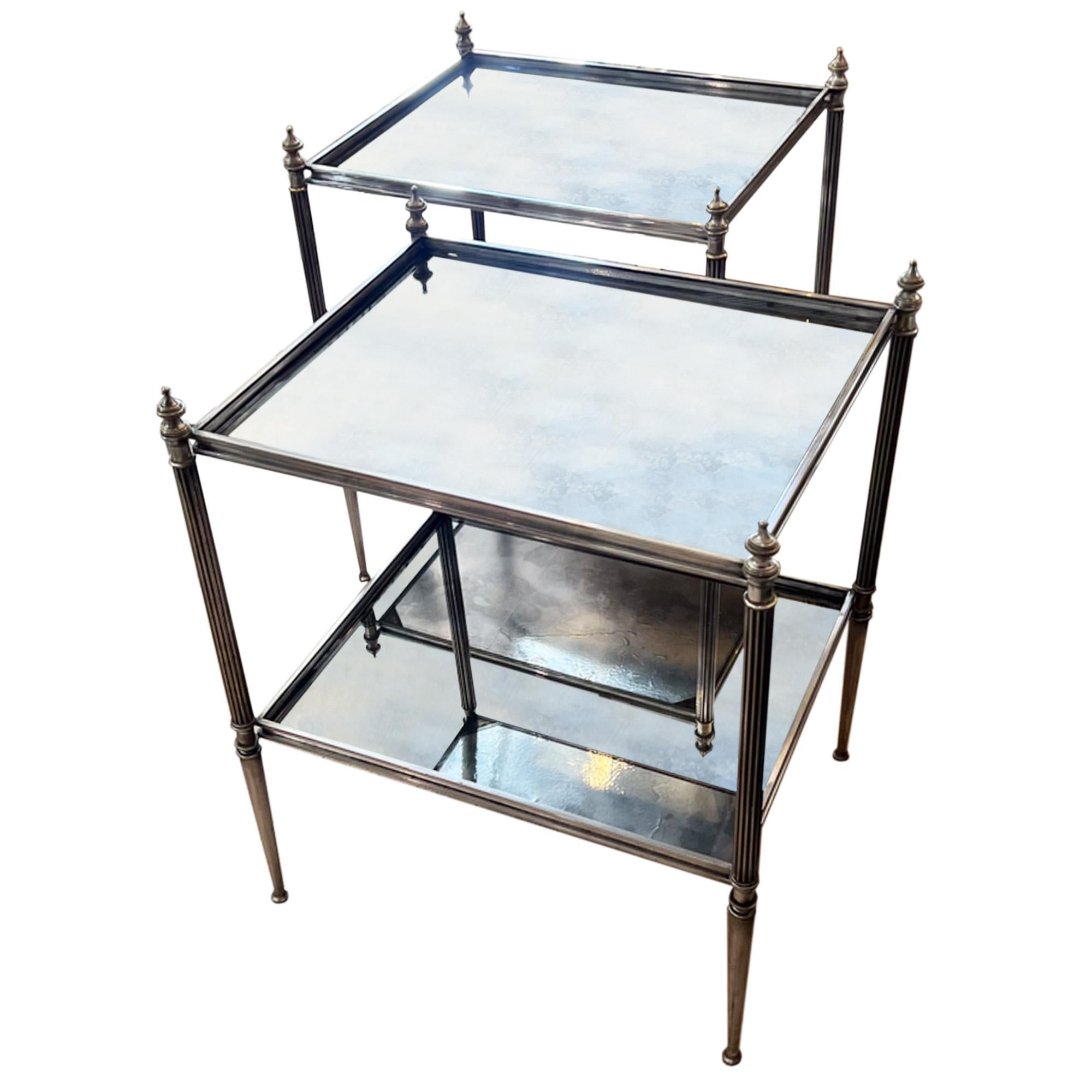 Une belle paire de tables d'appoint à deux niveaux fabriquées en France dans les années 1950. 

Fabriqué en laiton argenté et en verre églomisé, veuillez regarder toutes nos photos pour voir les magnifiques détails sur le verre, le cadre en métal et