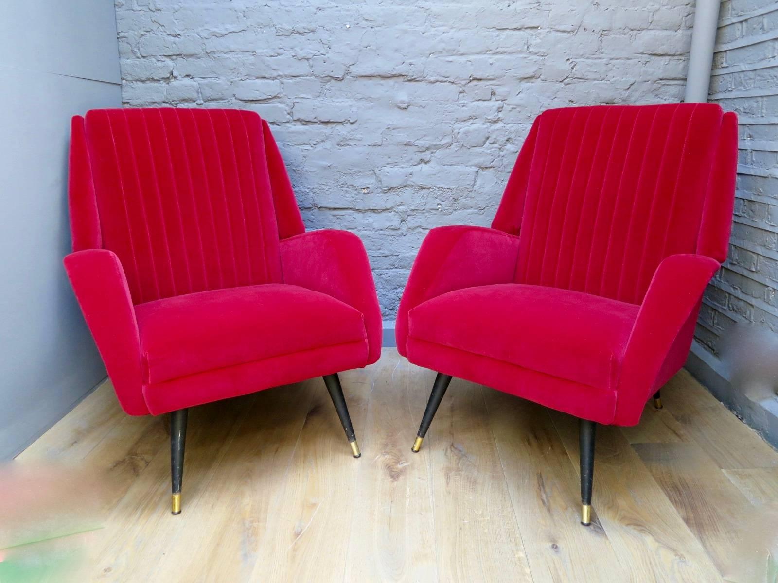 A pair of midcentury French chairs recovered in a red/Cerise velvet. With ribbed back, black metal legs and brass feet.