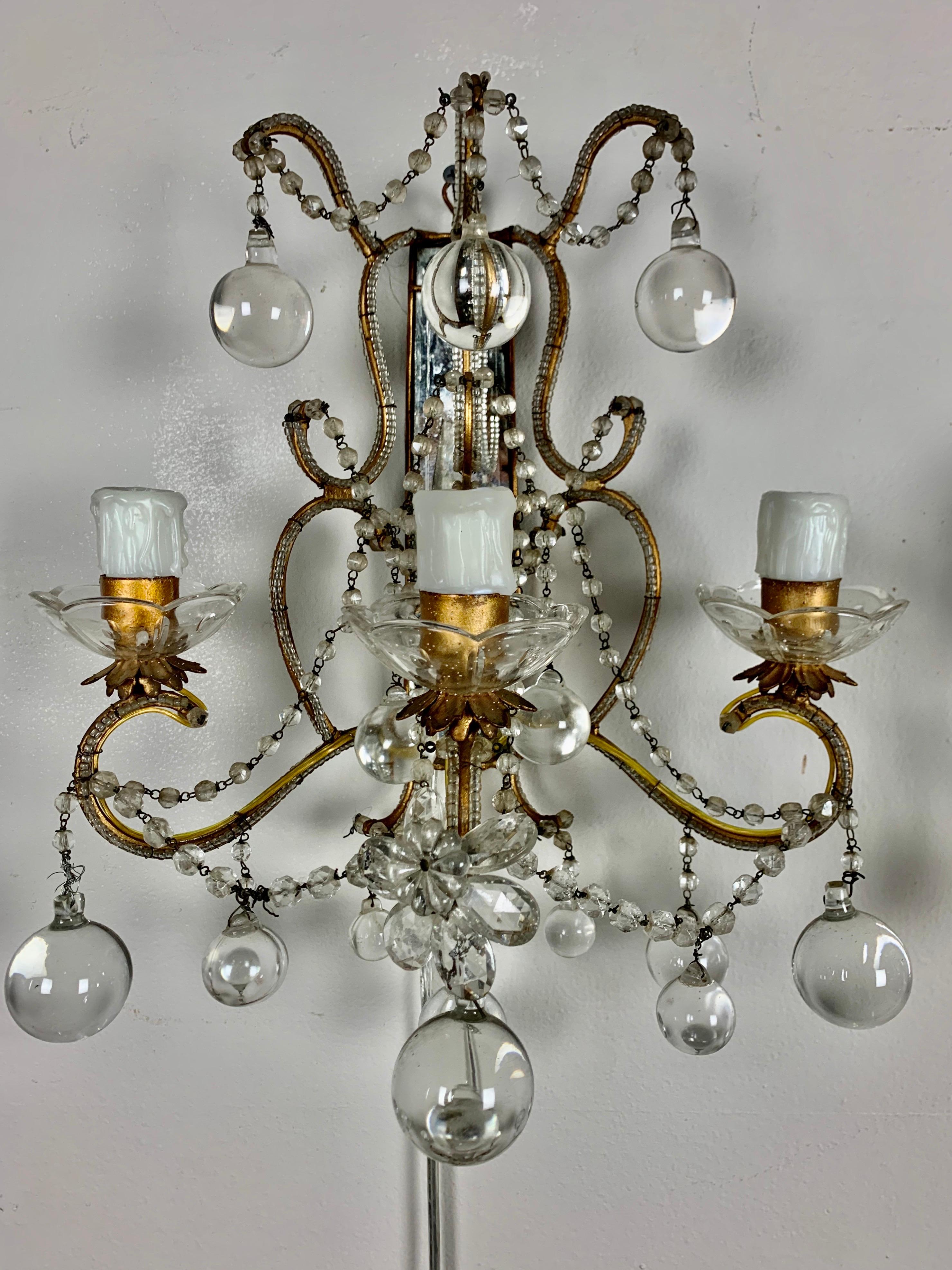 Pair of French crystal beaded mirrored 3-light sconce that have been newly wired with drip wax candle covers. Garlands of crystal beads throughout. Crystal drops adorn the pair of sconces as well.
    