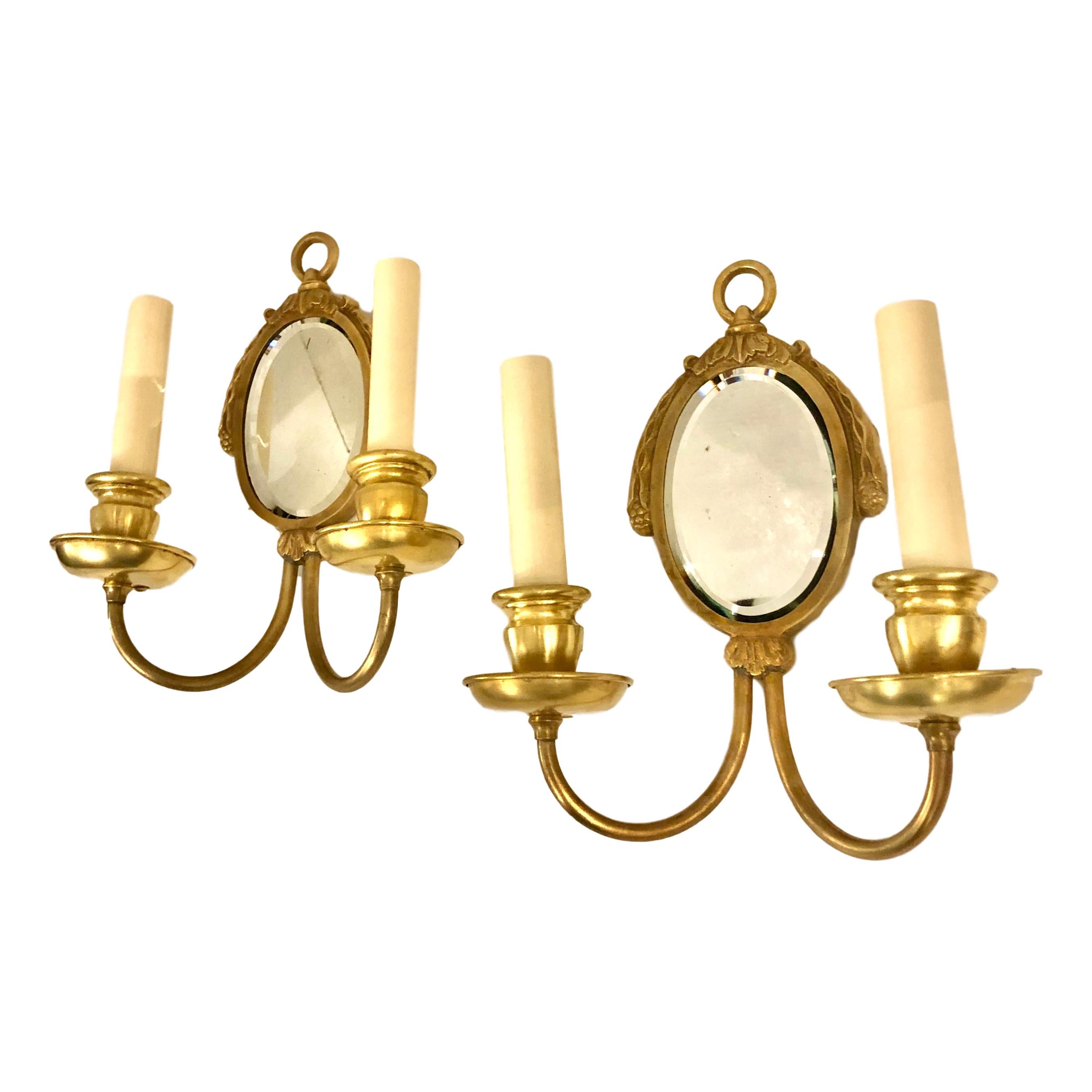 Pair of circa 1920's French gilt bronze double light sconces with mirror backs.
Measurements:
Height: 10.5