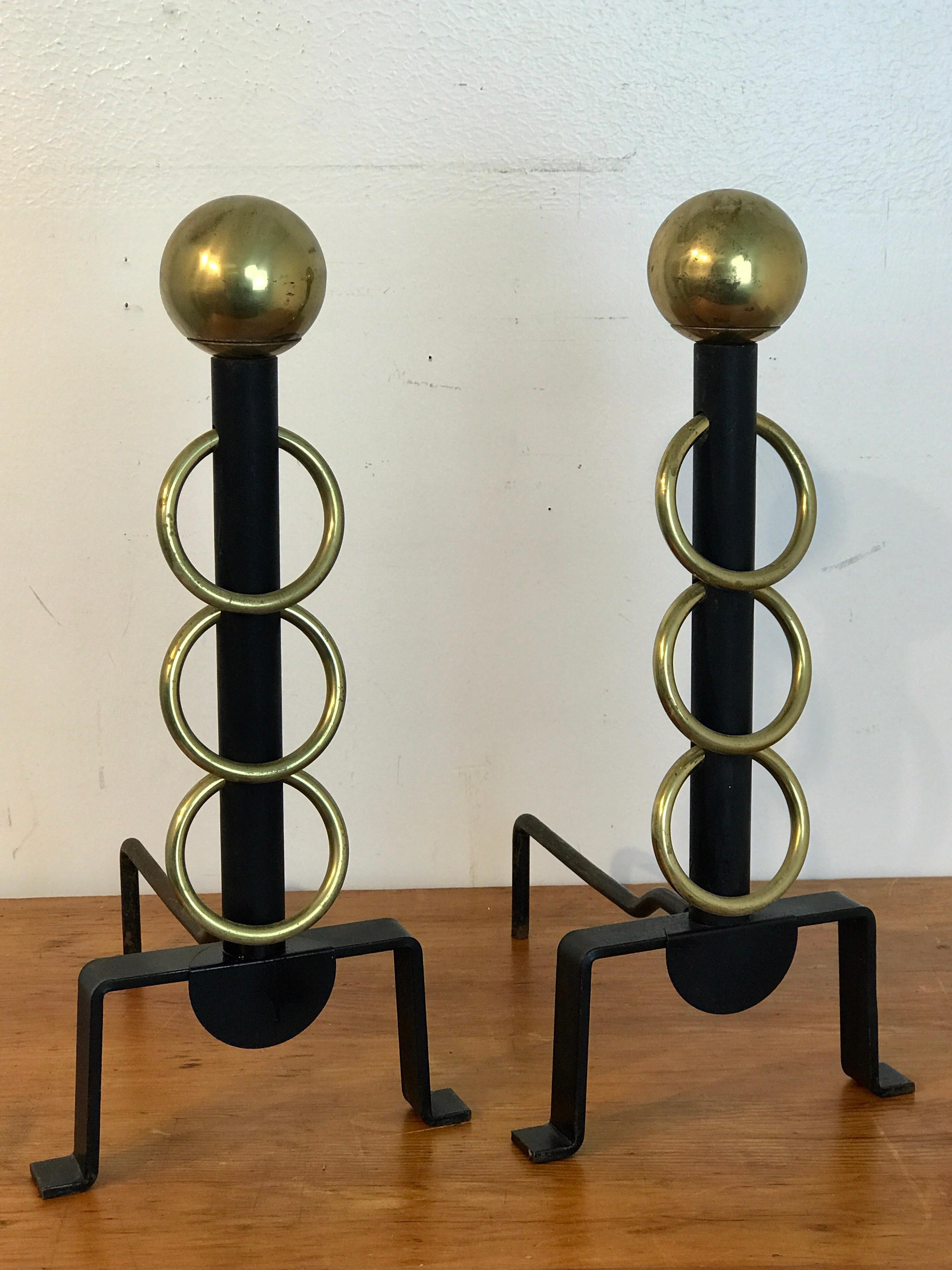 Pair of French modern brass and iron andirons, each one with brass sphere tops, fitted with three 4-inch diameter rings raised on a footed base.