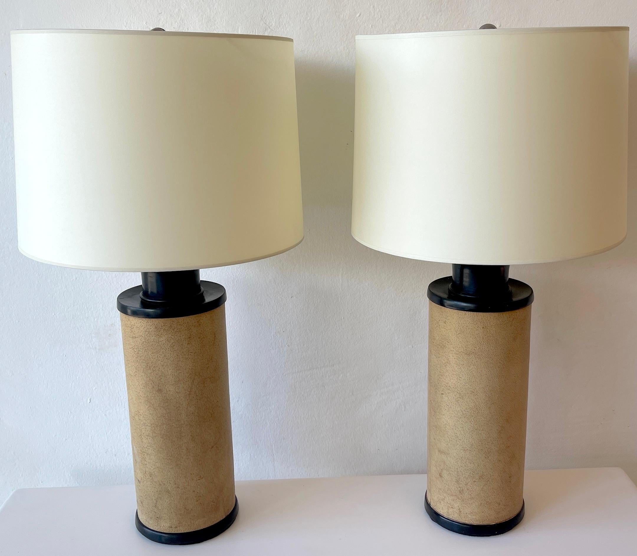 Pair of French modern ebonized wood & parchment leather lamps, style of JMF 
(Jean-Michel Frank 1895-1941)
Each one of cylinder column form with carved and ebonized mounts, the center with specimen parchment leather with beautiful patina. Fitted