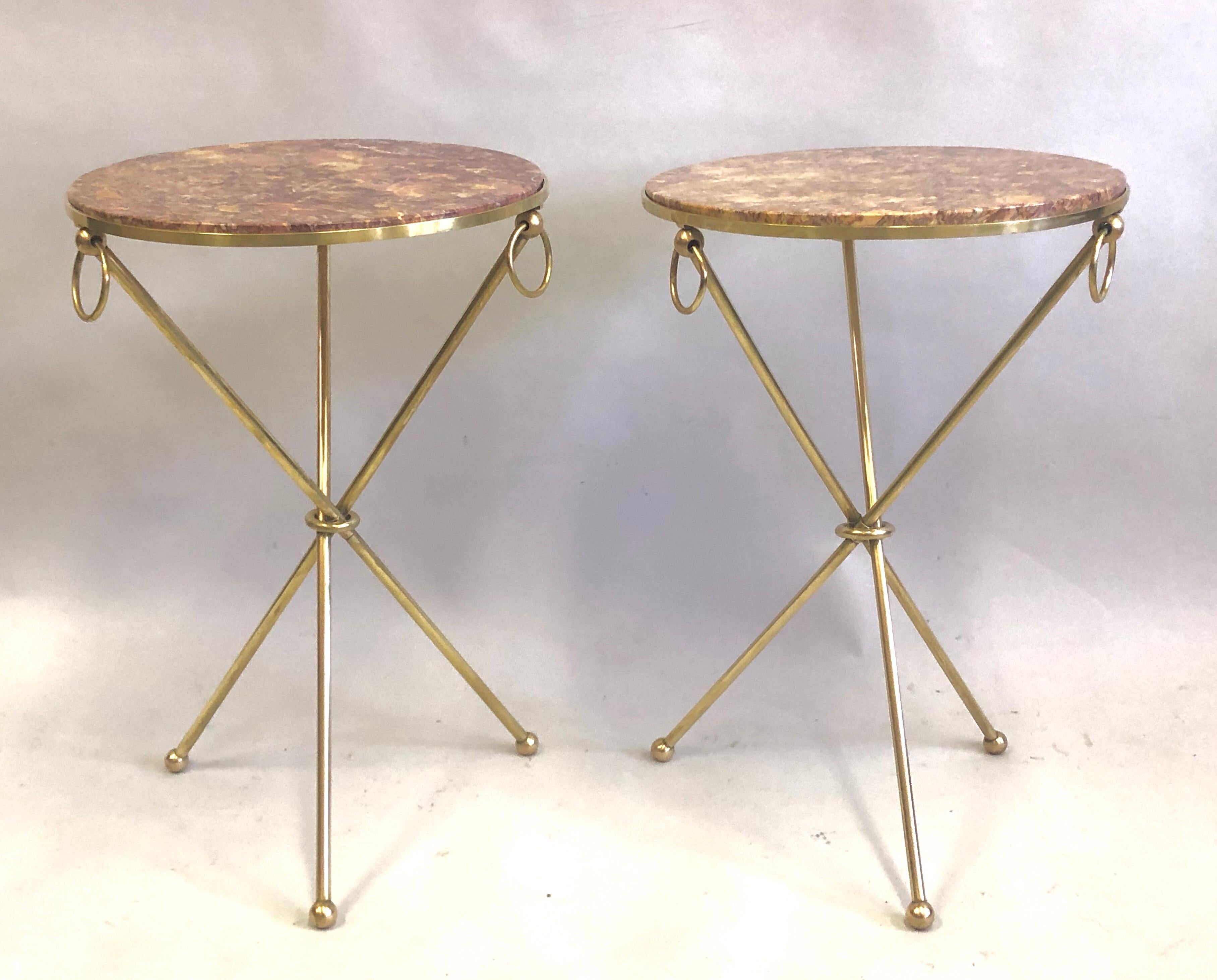 Elegant and timeless pair of French Mid-Century Modern neoclassical brass and marble side or end tables in the style of Jean-Michel Frank. 

The gueridons or tables are constructed in solid brass resting on tripod legs ending in ball feet. They