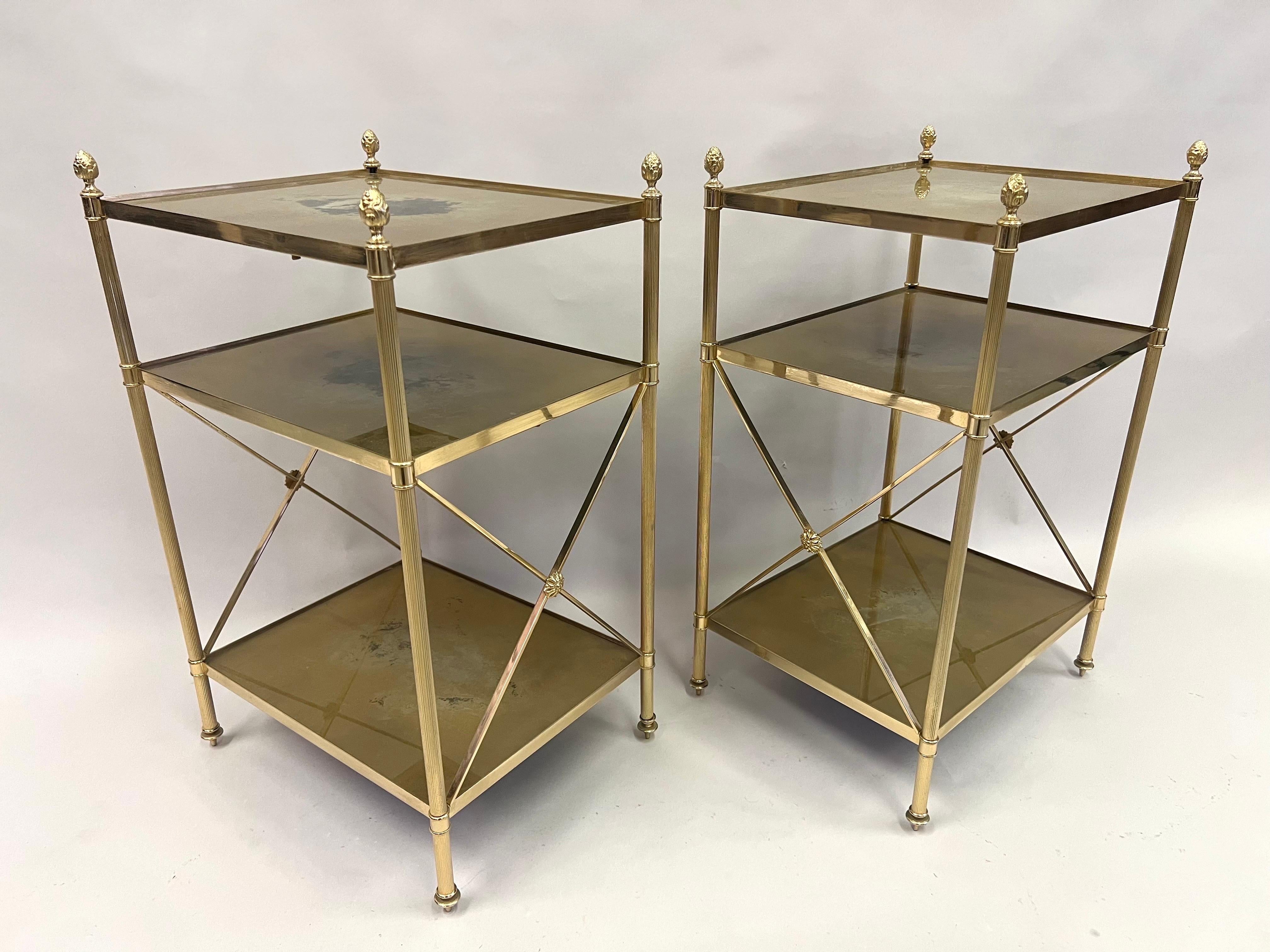 An Elegant and Timeless Pair of French Mid-Century Modern Neoclassical ,triple tier, side / end tables or nightstands in solid brass by Maison Jansen for Maison Bagues. The tables are composed of the highest quality solid brass frames with 3 inset