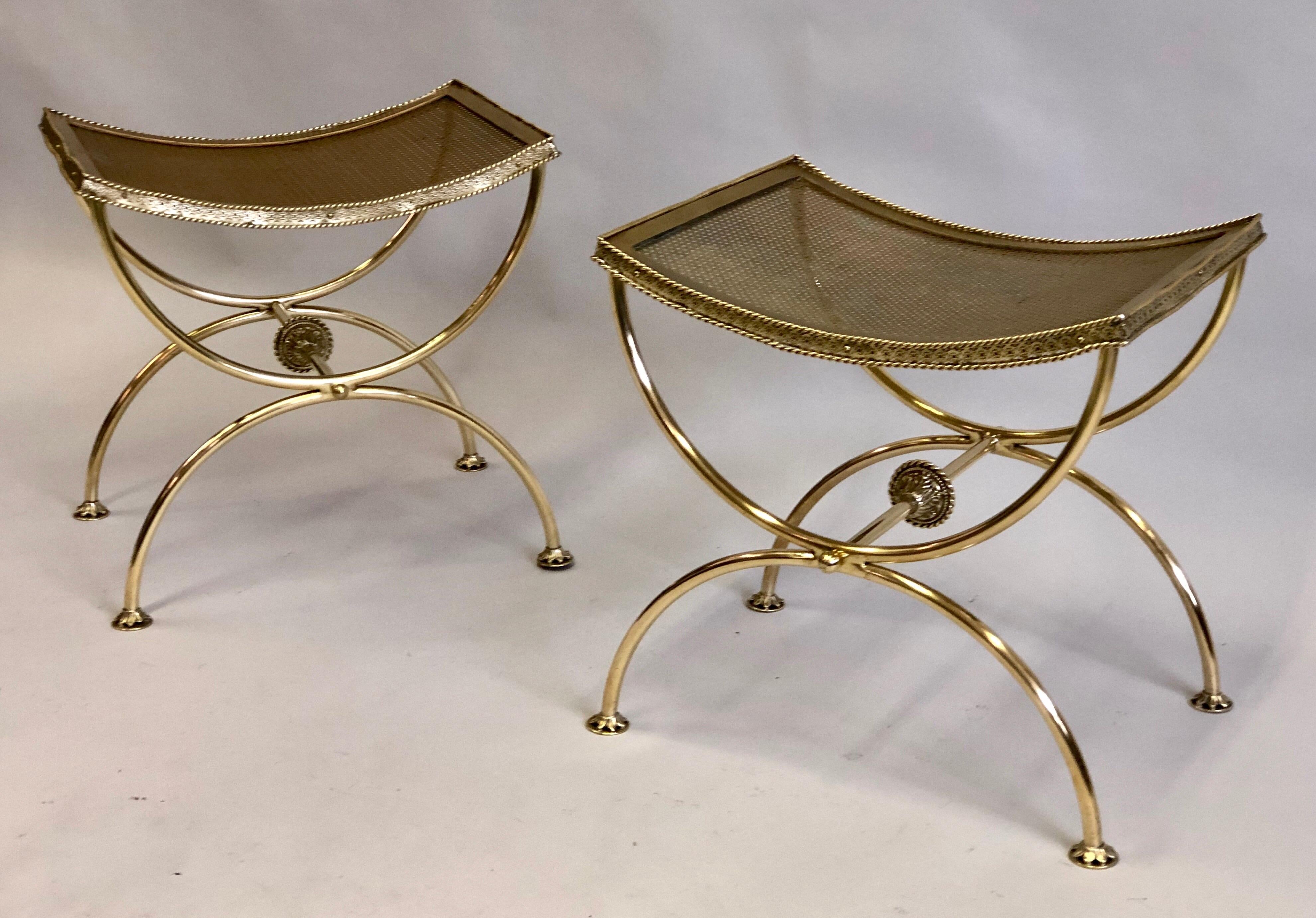 Elegant Pair of French Mid-Century Modern Neoclassical Gilt Bronze / Solid Brass Benches or Stools by Maison Bagues.
The pieces feature a classical Curile or X-frame leg structure which supports a shaped seat for comfort. Ball finials complete the