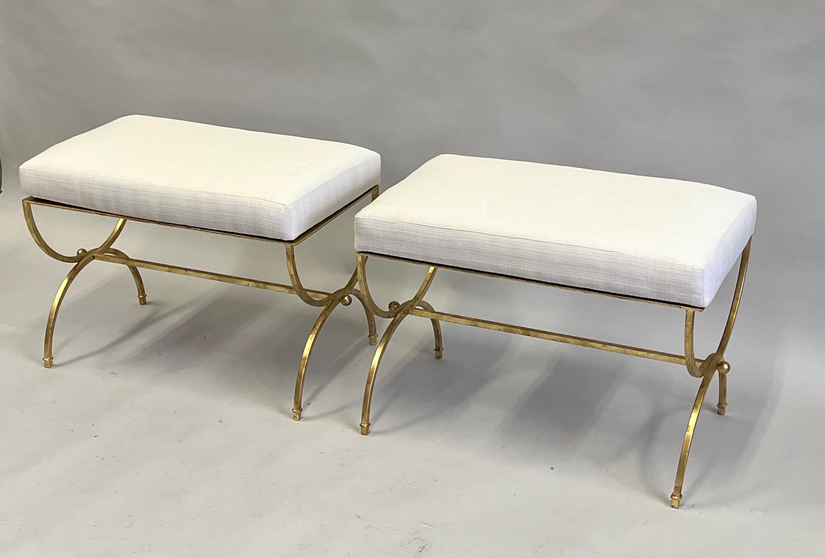 Elegant, Timeless Pair of French Mid-century, Modern neoclassical, hand made gilt wrought iron benches or stools in the style of Raymond Subes, France, 1930. The pieces are exquisitely detailed with a Curile, X frame leg design reminiscent of