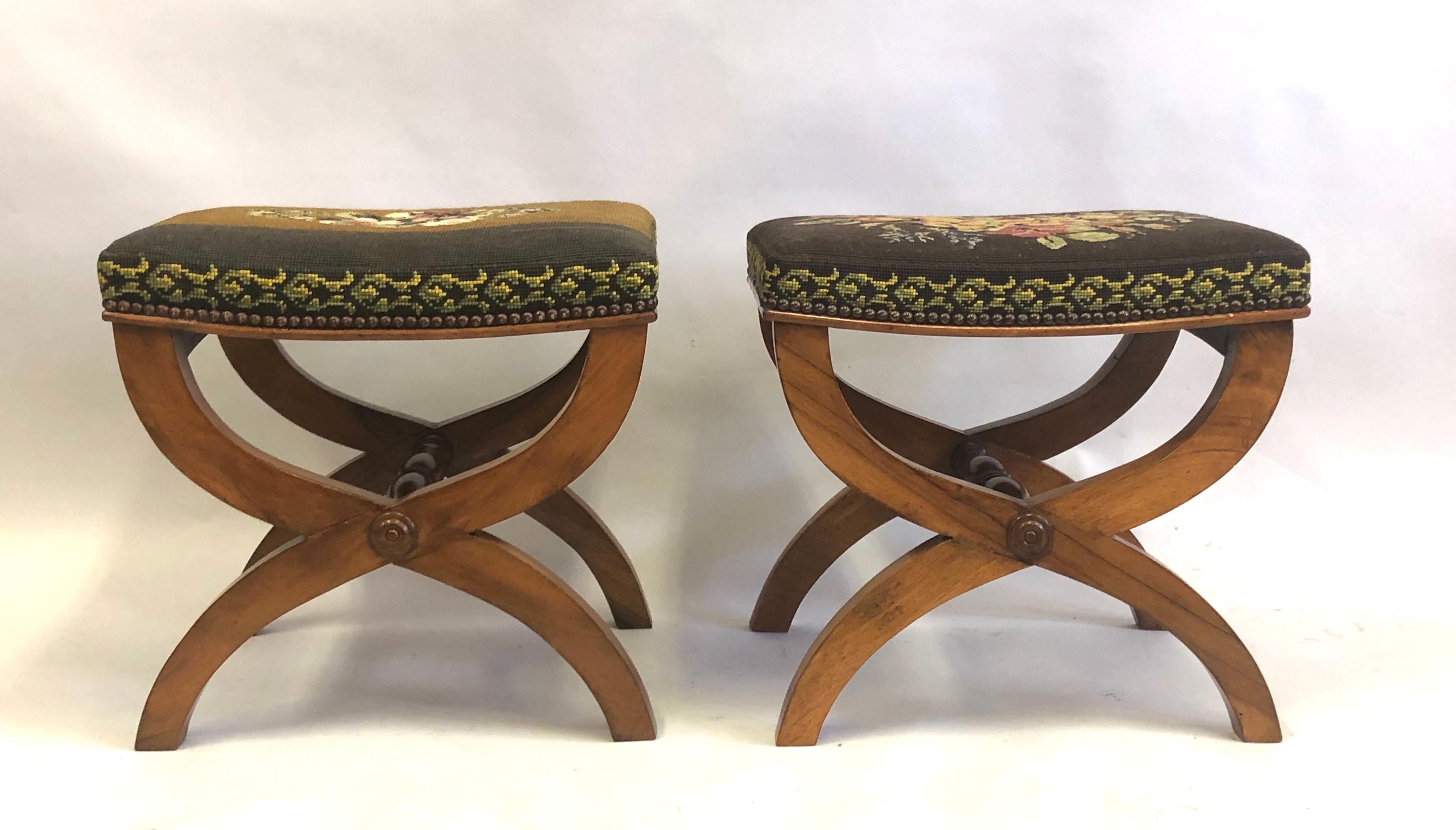 Pair of French Mid-Century Modern neoclassical benches or stools with needlepoint seats attributed to Andre Arbus. The benches are in the curile form with and an X-frame leg structure.