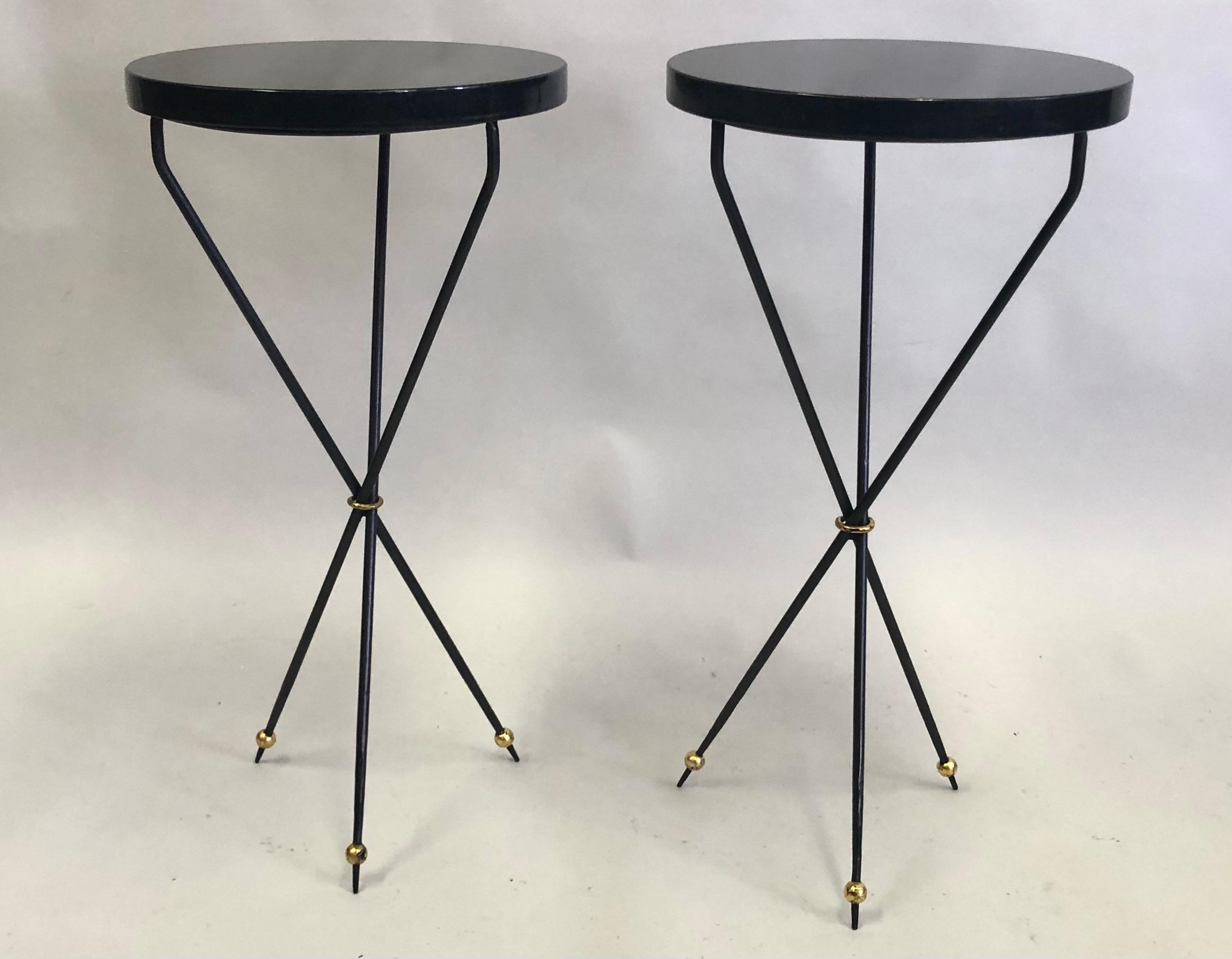 A delicate, refined pair of French Mid-Century Modern neoclassical side or end tables / gueridons in the spirit of Jean Michel Frank. The pieces are composed of a pure, sober, minimal, yet dramatic tripod form. The legs are long, thin and angled