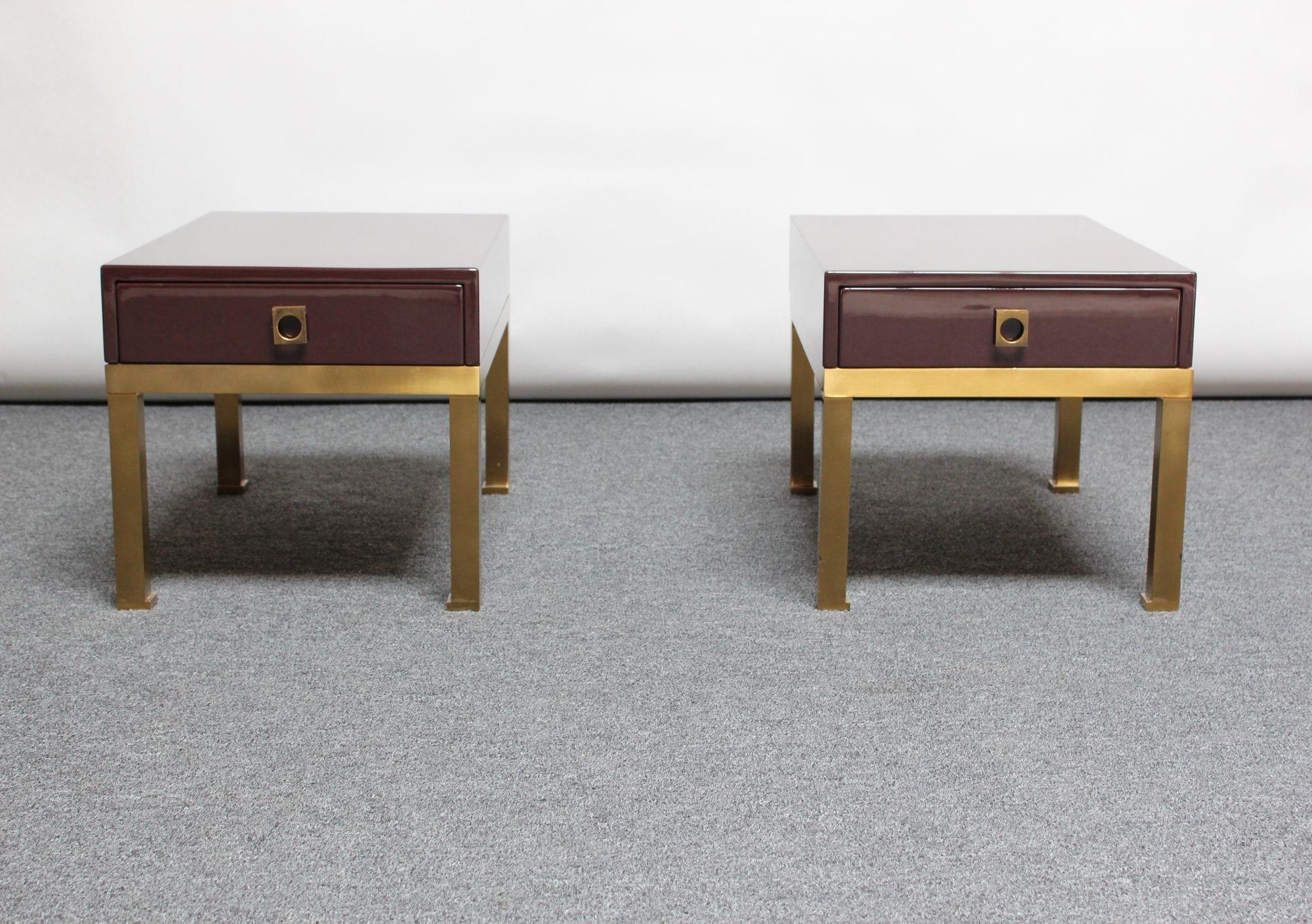 Exquisite, low side tables/nightstands designed by Guy Lefèvre for Maison Jansen (ca. 1975, France). Composed of lacquered mahogany chests supported by brass cradles. Single drawers smoothly slide open via modernist, sculptural, brass pulls.
