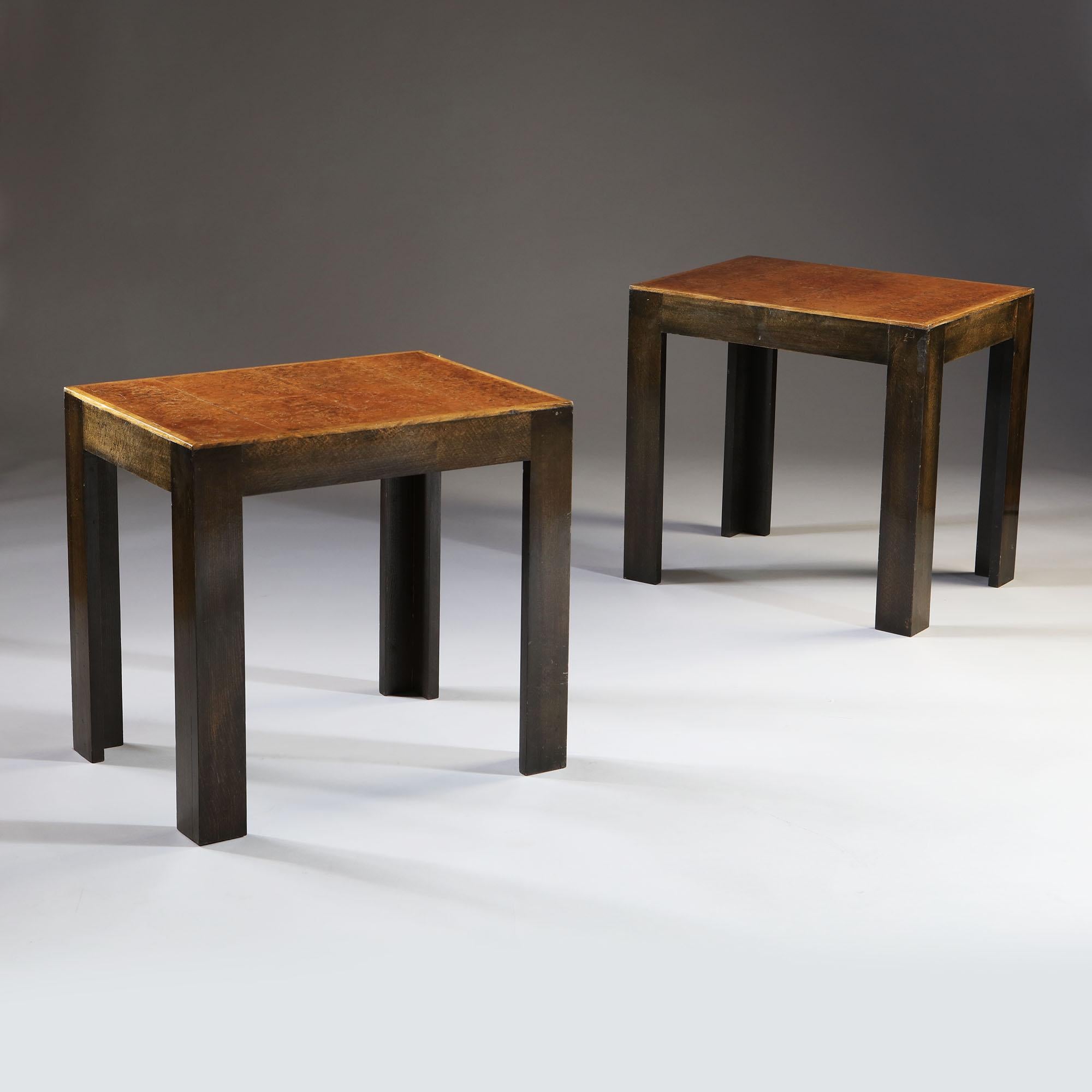 A pair of early 20th century French tables in the Modernist style, with amboyna veneer to the tops and ebonized legs.