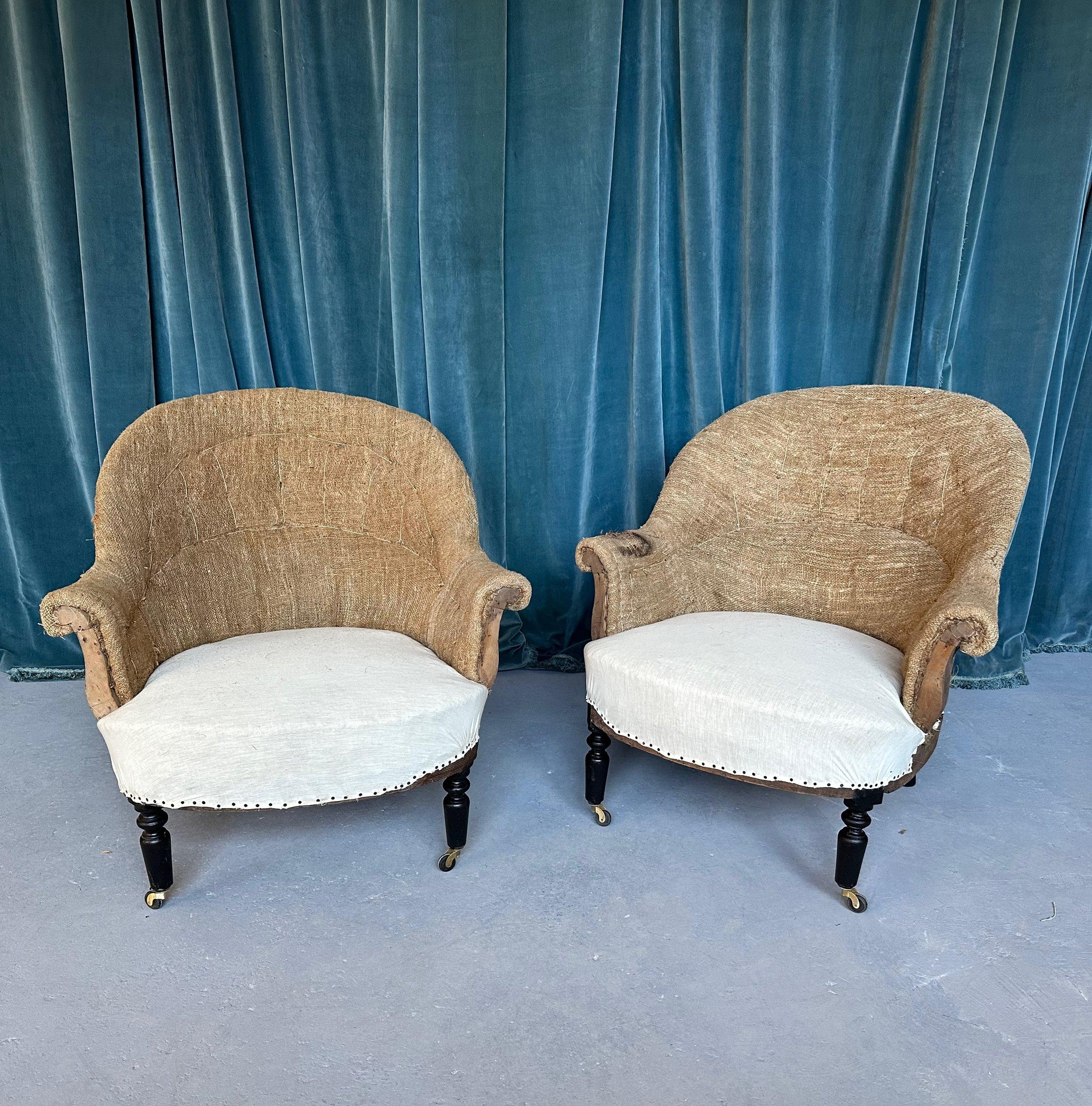 A classic pair of French 19th century Napoleon III style armchairs with gracious rounded backs and gently scrolled arms. These chairs are designed with impeccable proportions, featuring a generously curved back that offers outstanding lumbar support