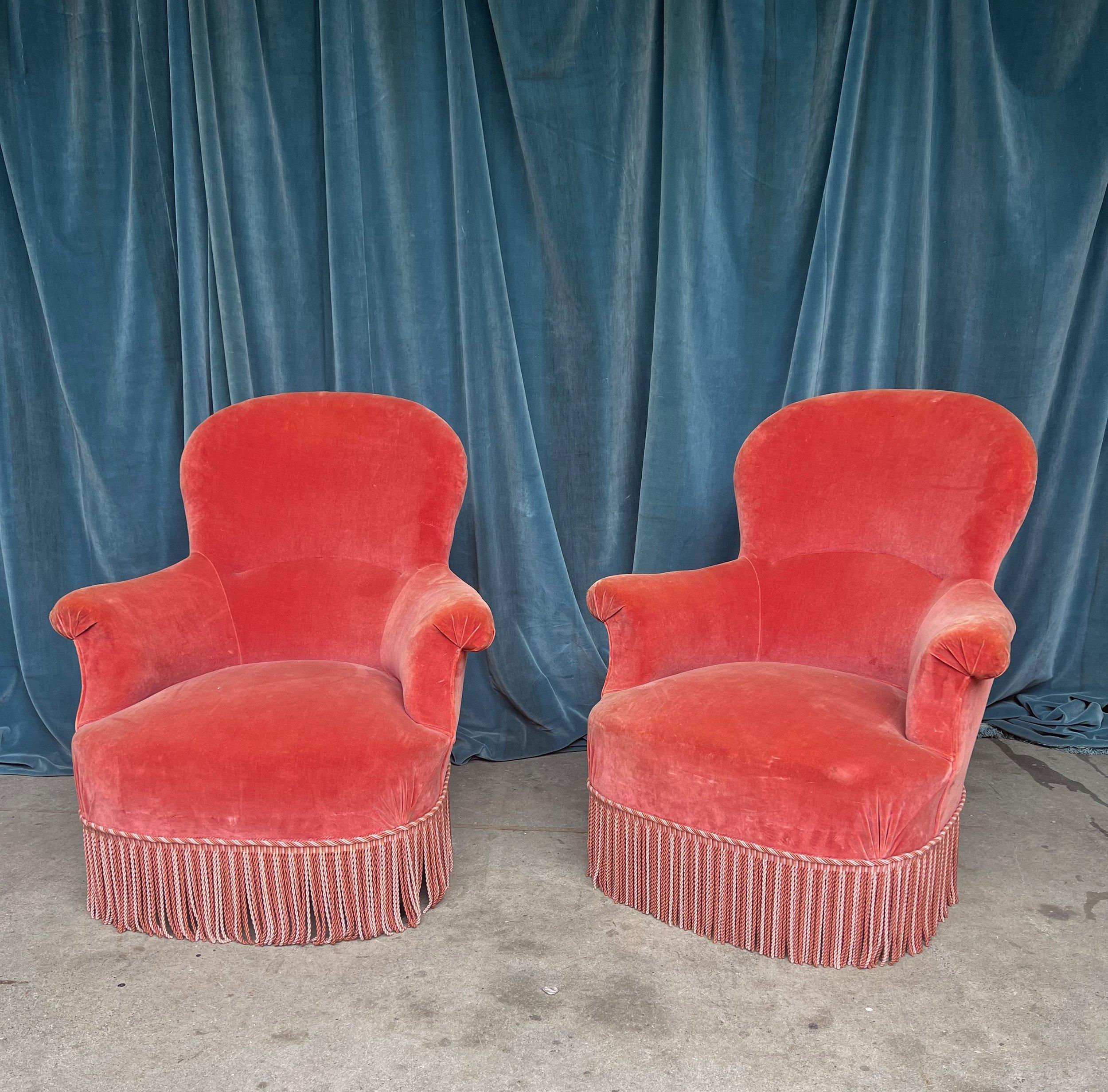 Une paire de fauteuils Napoléon III du XIXe siècle, aux proportions merveilleuses, dégageant une élégance et une sophistication intemporelles. Ces superbes chaises sont tapissées de velours rose vintage, complété par une frange bullion contrastante