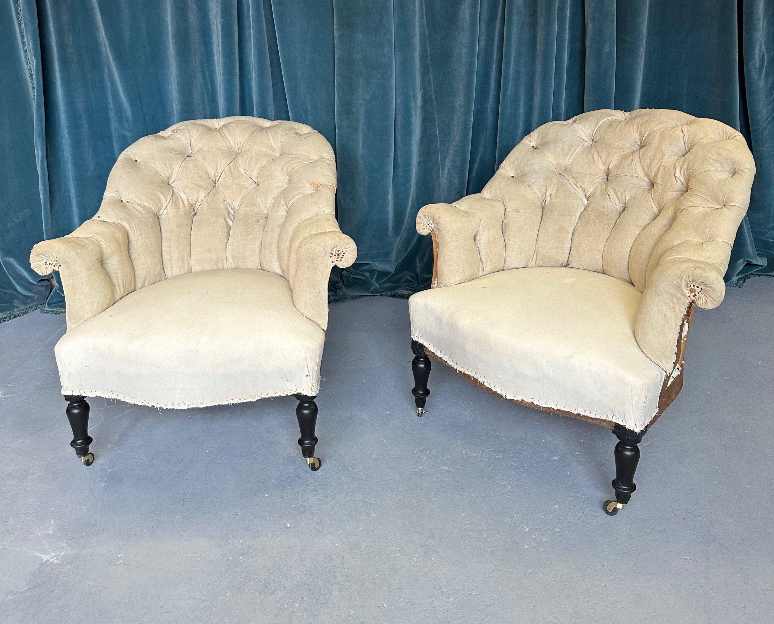 A handsome pair of French 19th century armchairs with diamond tufted backs and scrolled arms. This pair of armchairs from the Napoleon III period captures the intricate details and romantic beauty that is typical of this period in French design. The