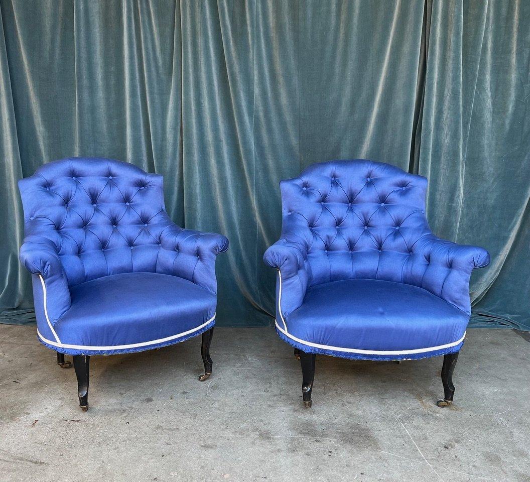 An exquisite pair of French Napoleon III tufted armchairs. Upholstered in a stunning vintage blue fabric, these chairs have a serious presence that pairs beautifully with traditional decor. The “chapeau de gendarme” style backs are heavily tufted